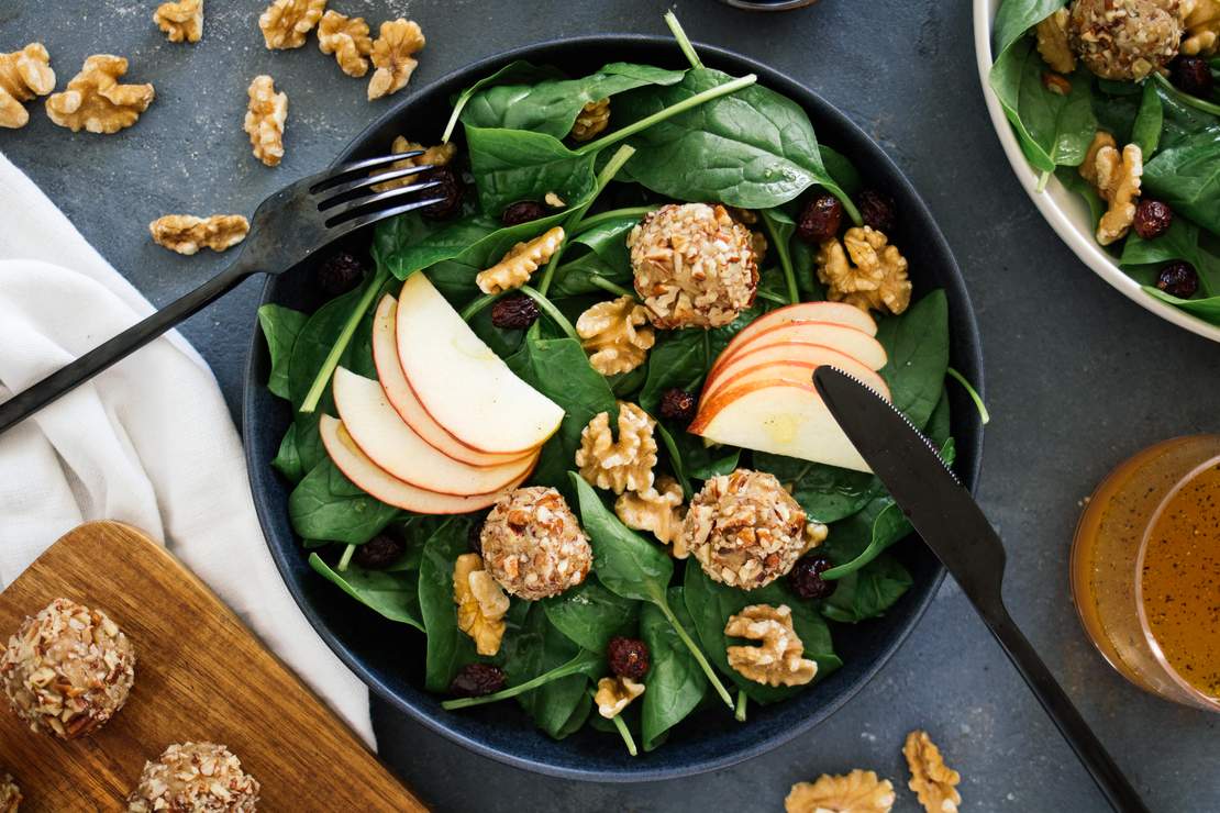 R129 vegan cheese balls on a salad with apple & cranberry