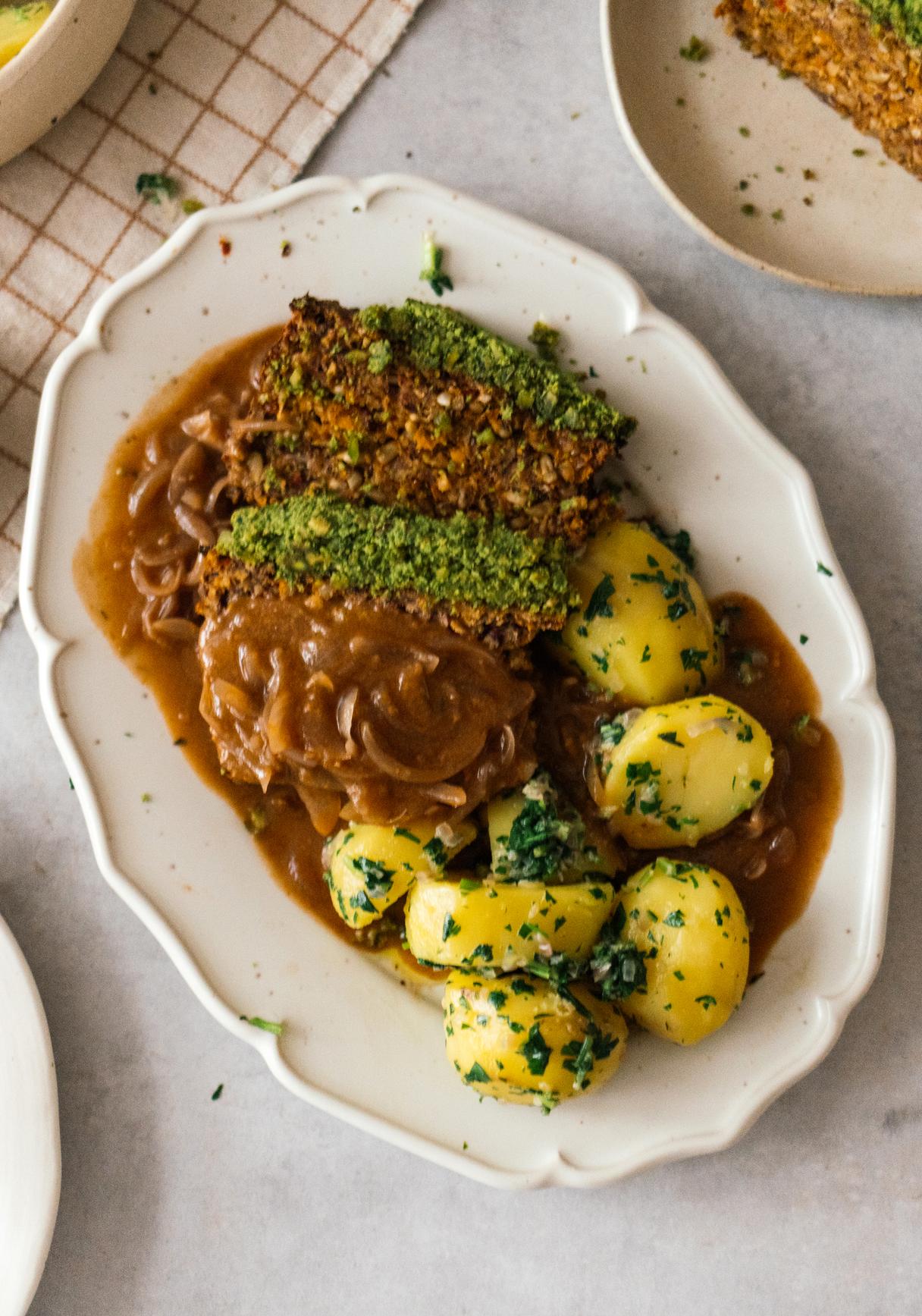 Veganer Braten mit Kräuterkruste, Petersilienkartoffeln und Zwiebelsoße