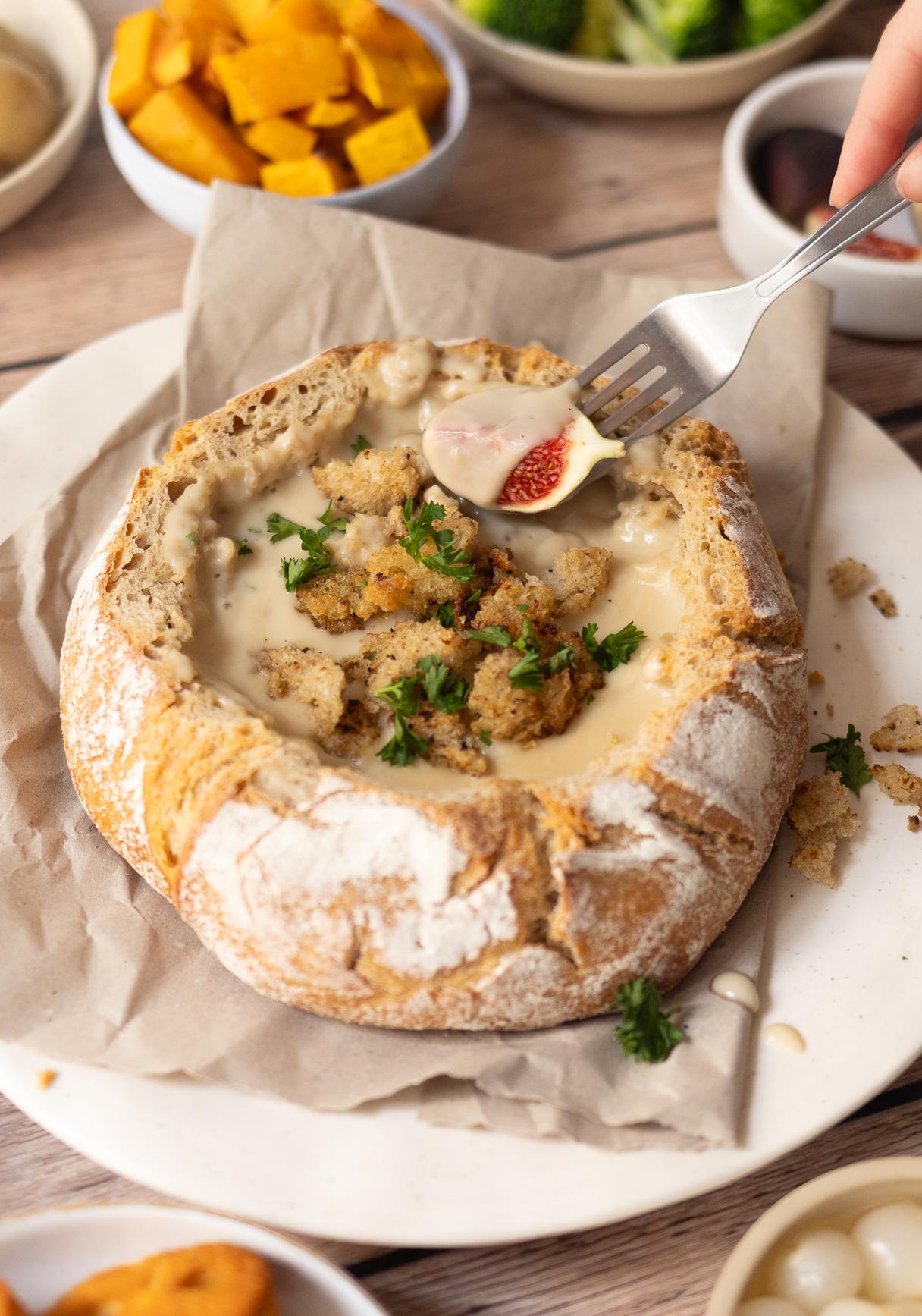 Veganes Käsefondue aus dem Brot mit knusprigem Topping