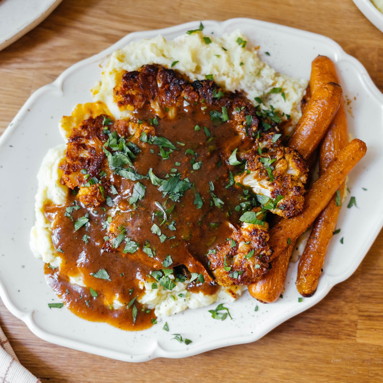 Gebackener Blumenkohl mit Kartoffelbrei, glasierten Möhren und Veganer Bratensoße