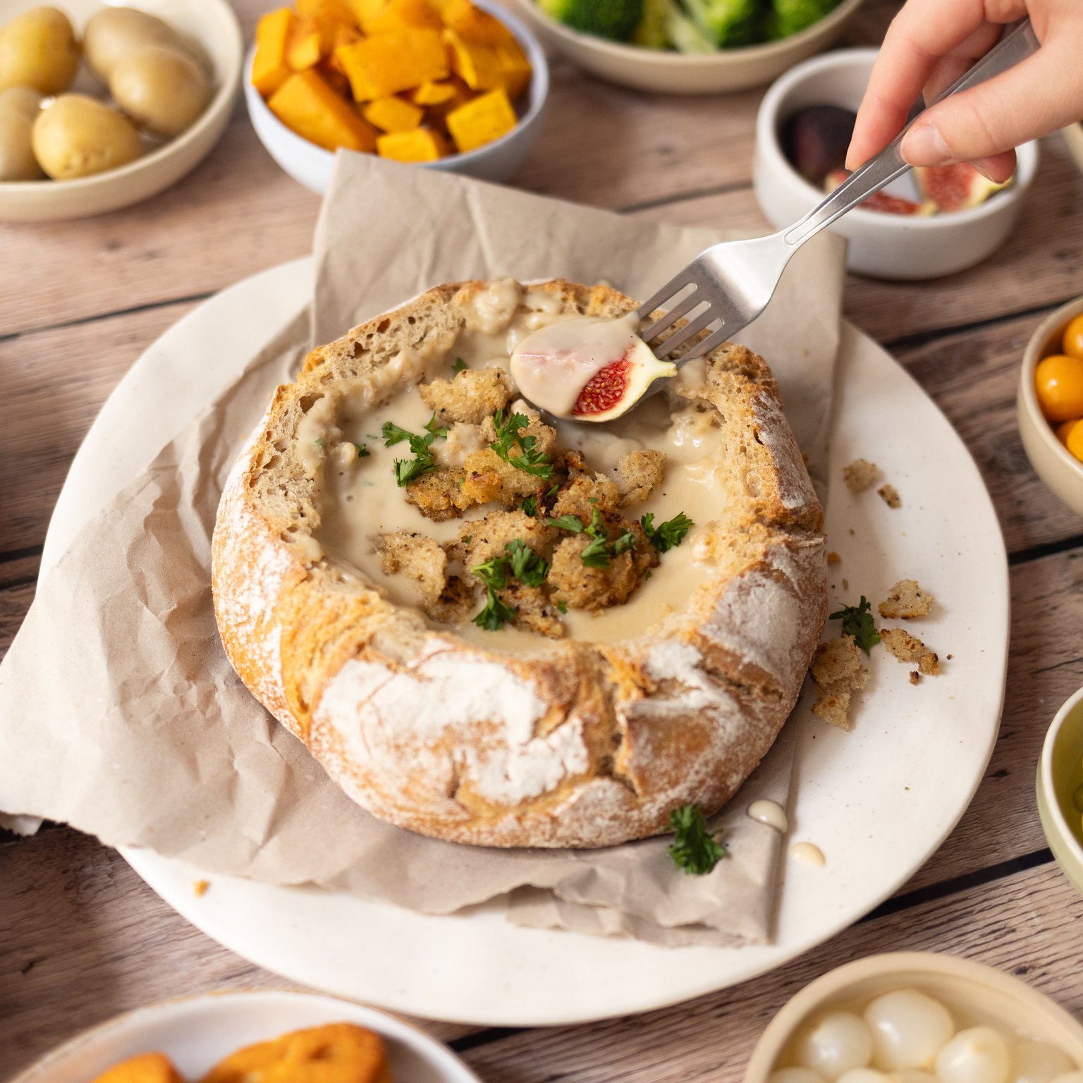 Veganes Käsefondue aus dem Brot mit knusprigem Topping
