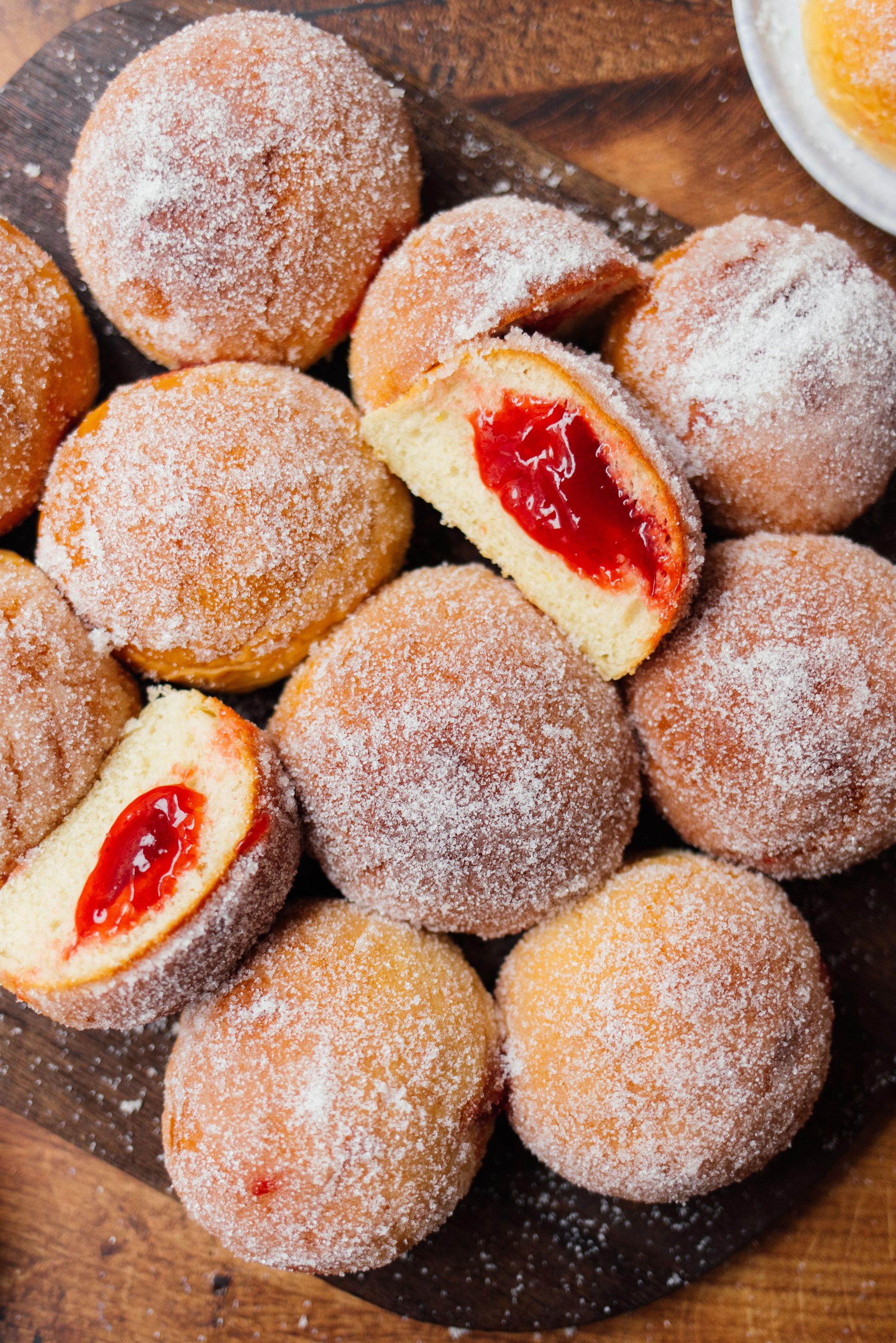 vegan doughnuts from the oven stacked on a board and partially cut