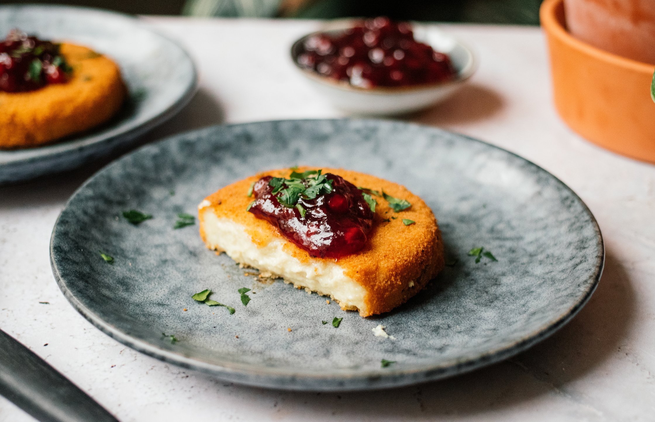 veganer backcamembert auf einem teller mit preiselbeermarmelade