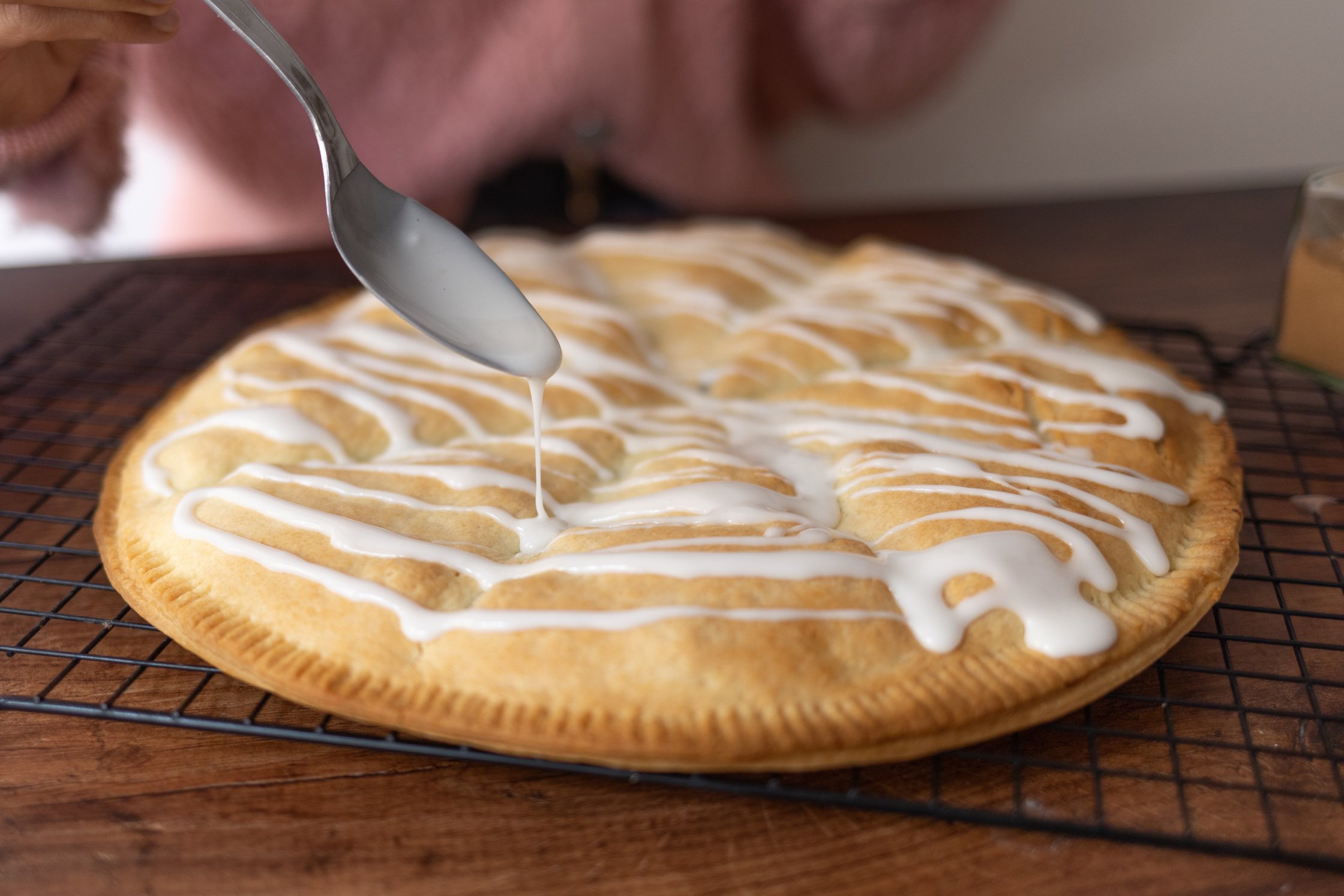 veganer apfel-kirsch Hand Pie wird mit zuckerguss verziert