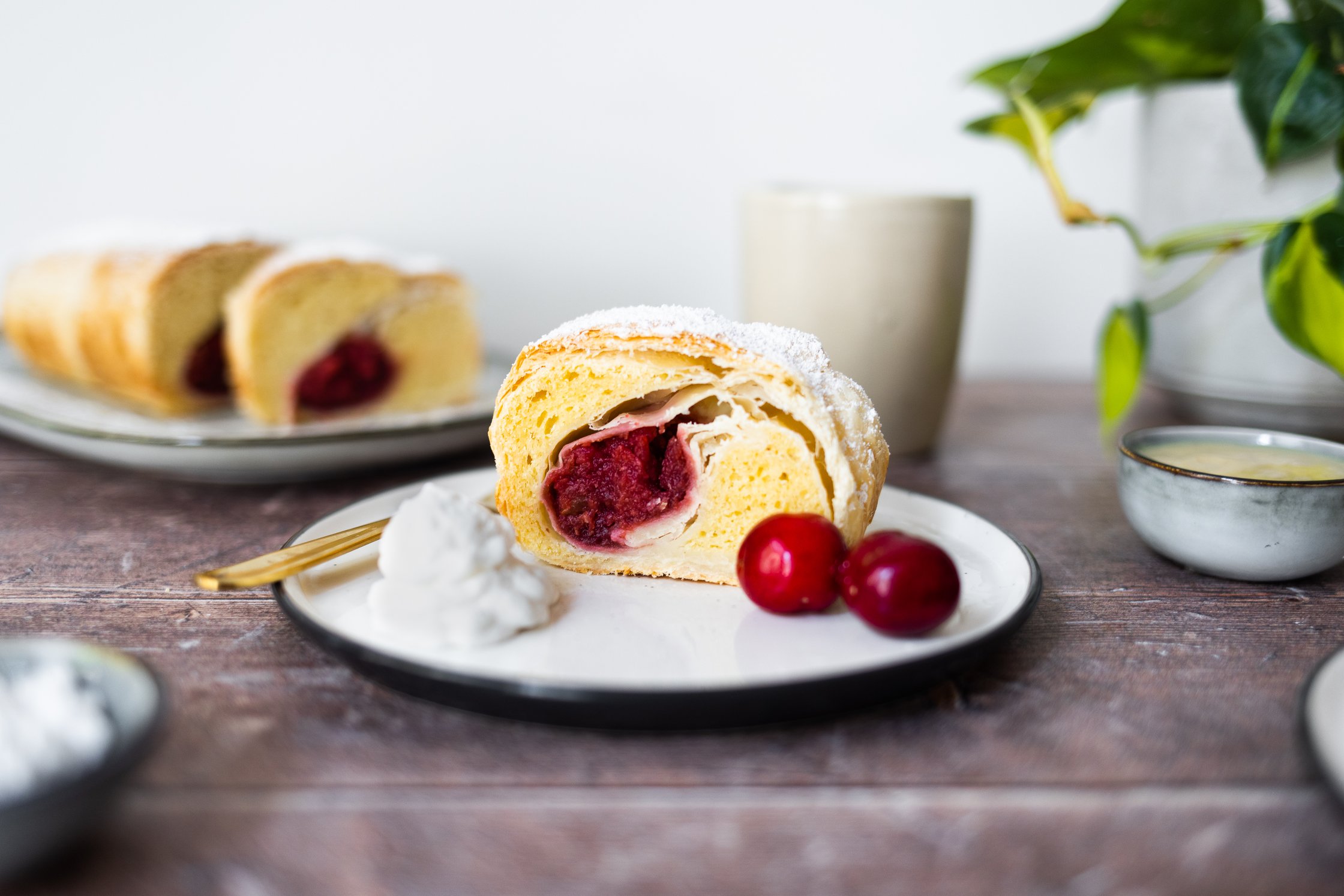 Vegan curd strudel with cherries served on a plate.