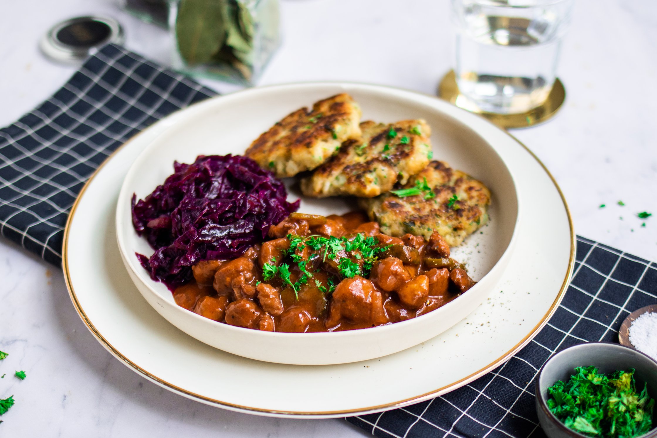 Vegan goulash with red cabbage and pan dumplings arranged on a plate