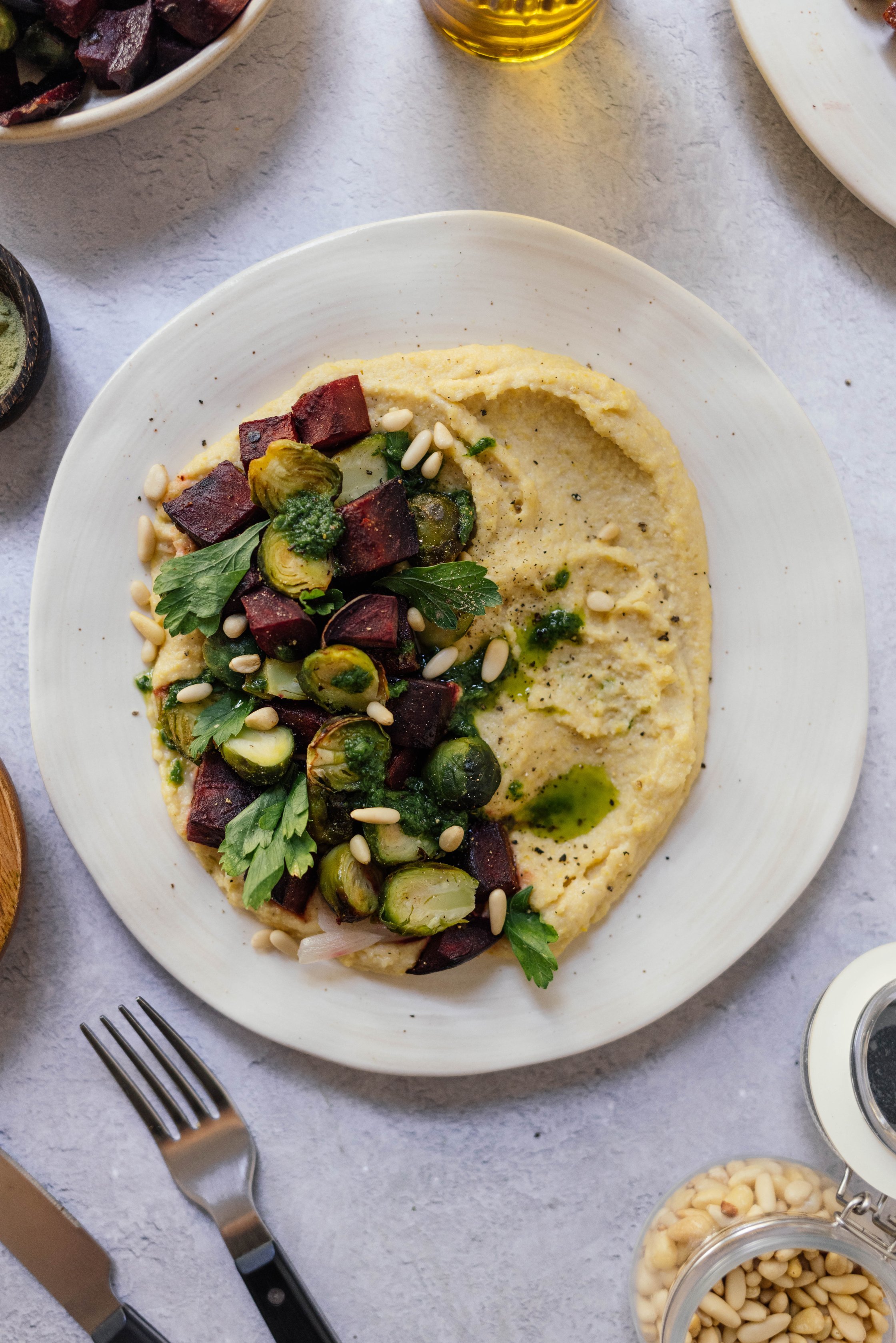 Servierte Polenta mit Rosenkohl und rote Beete auf einem Teller.