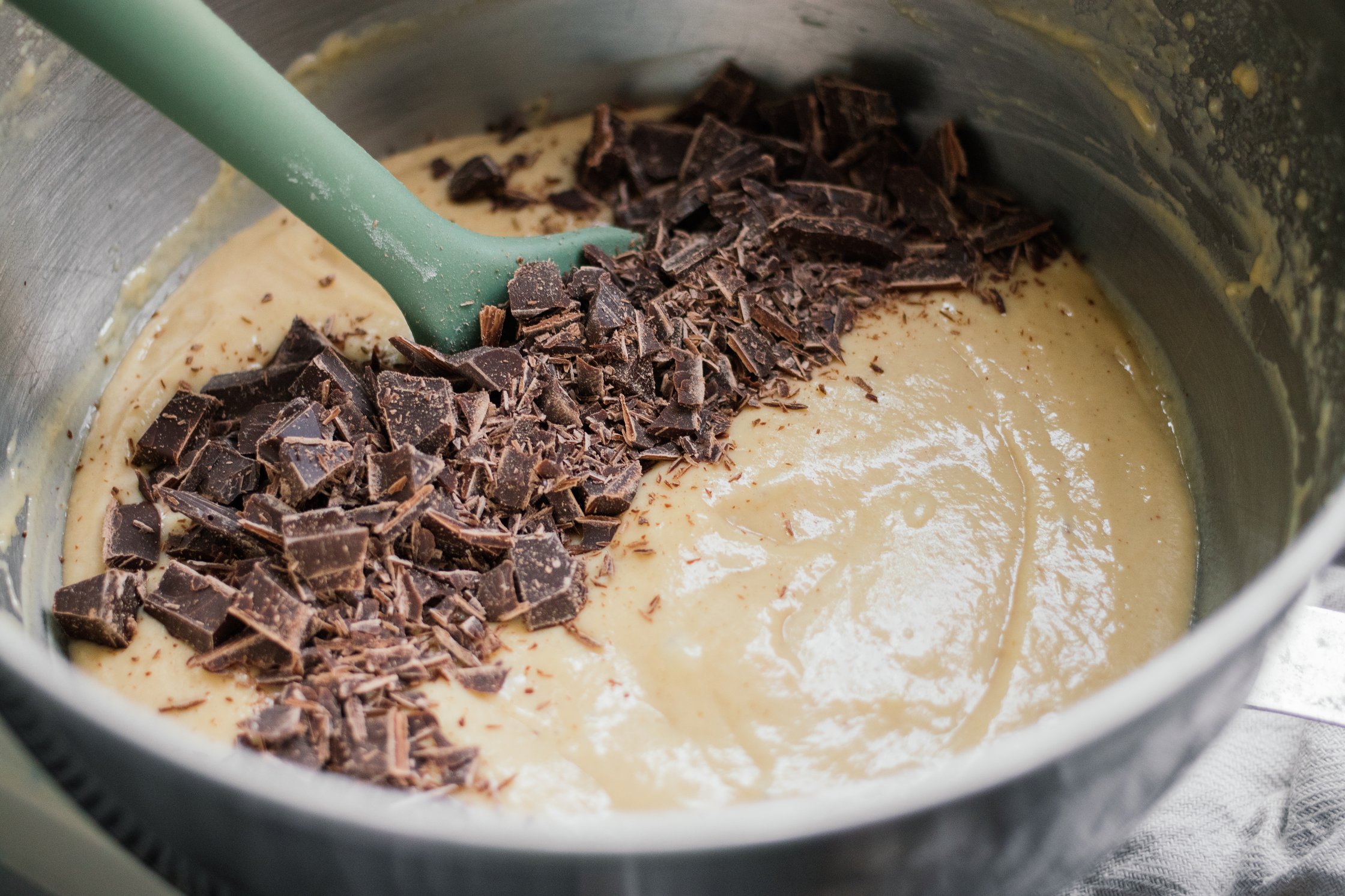 adding chocolate chips to batter for vegan peanut cake