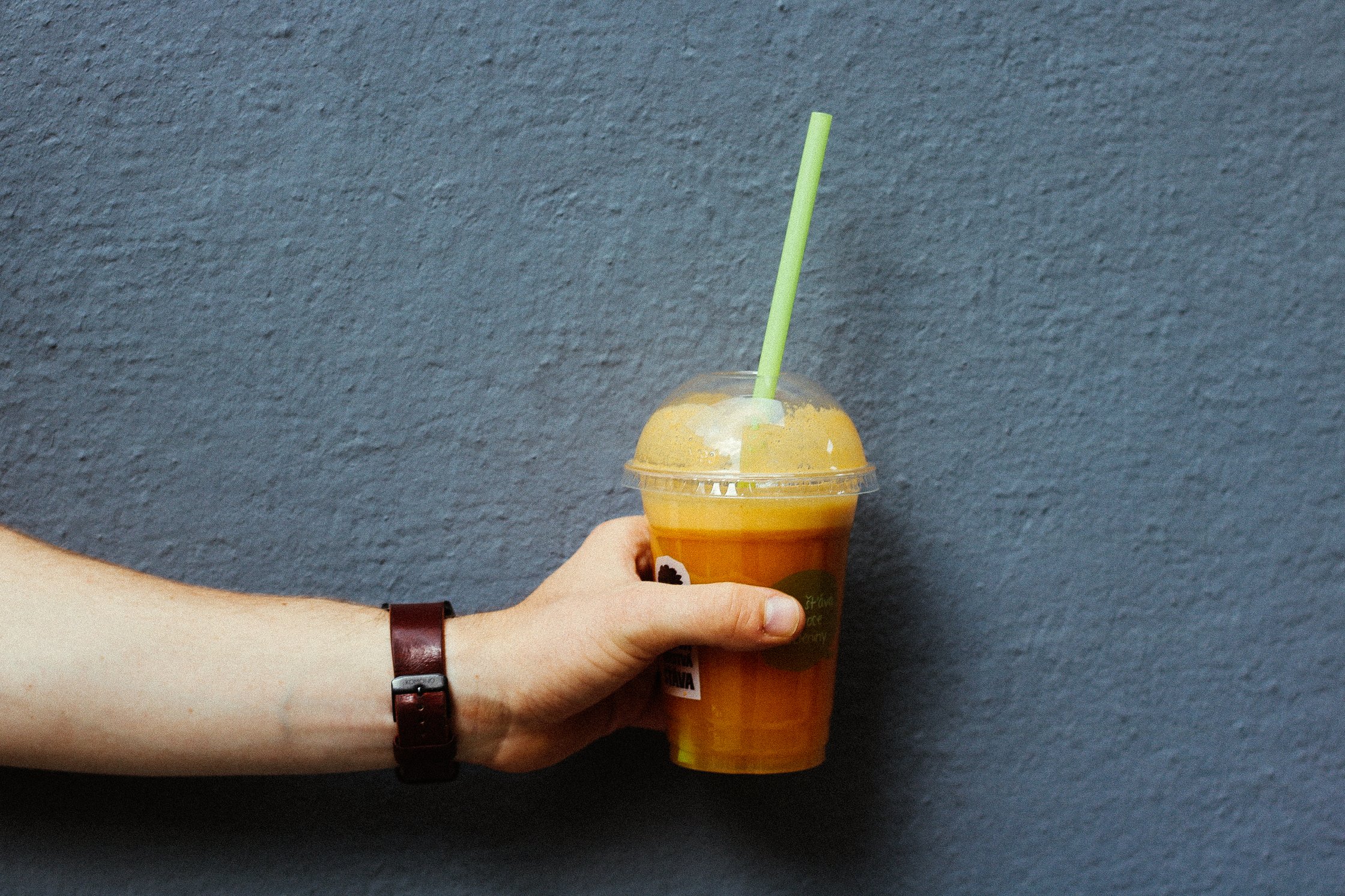eine Hand hält einen Smoothie