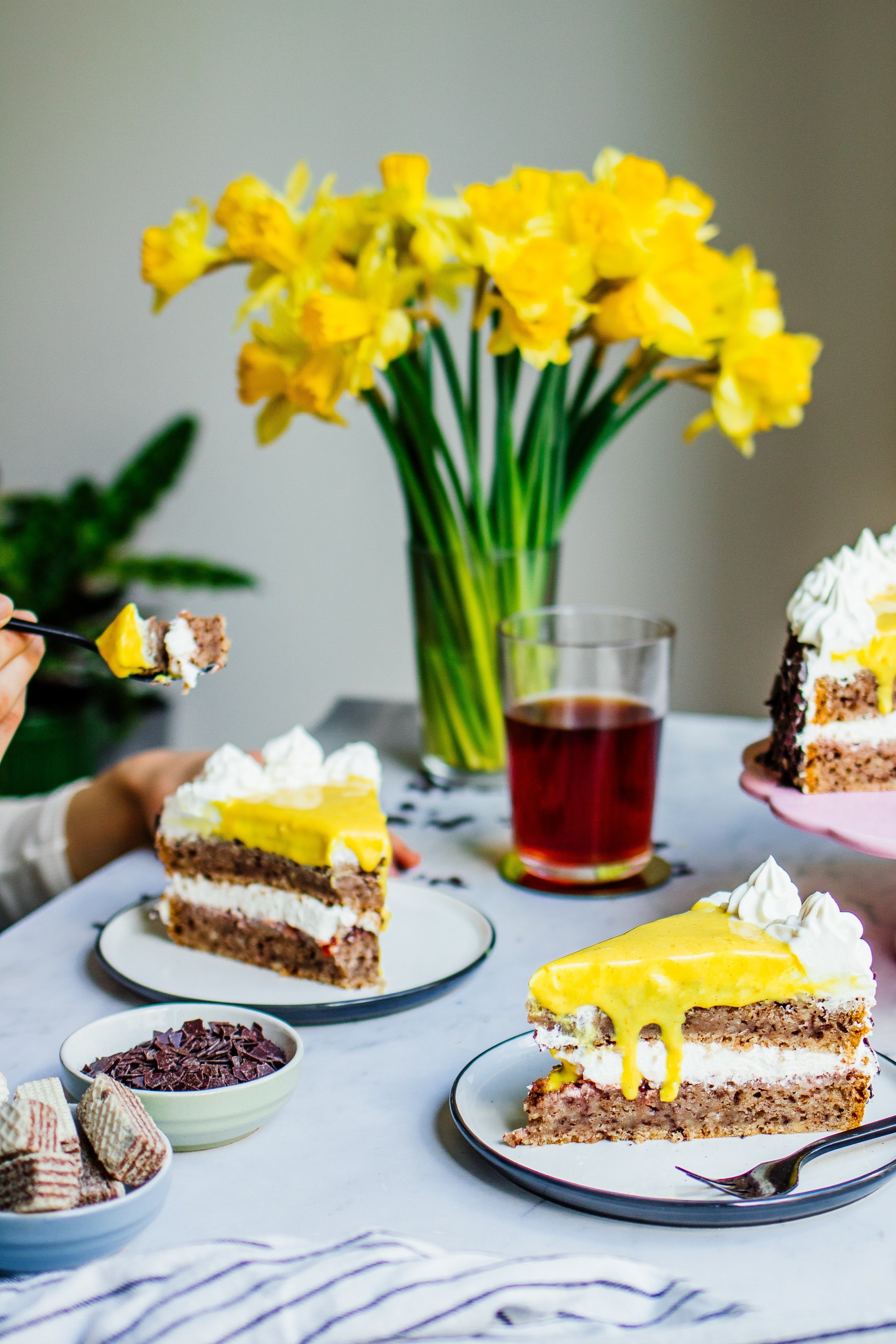 vegane Eierlikörtorte mit Haselnussböden serviert auf einem Tisch