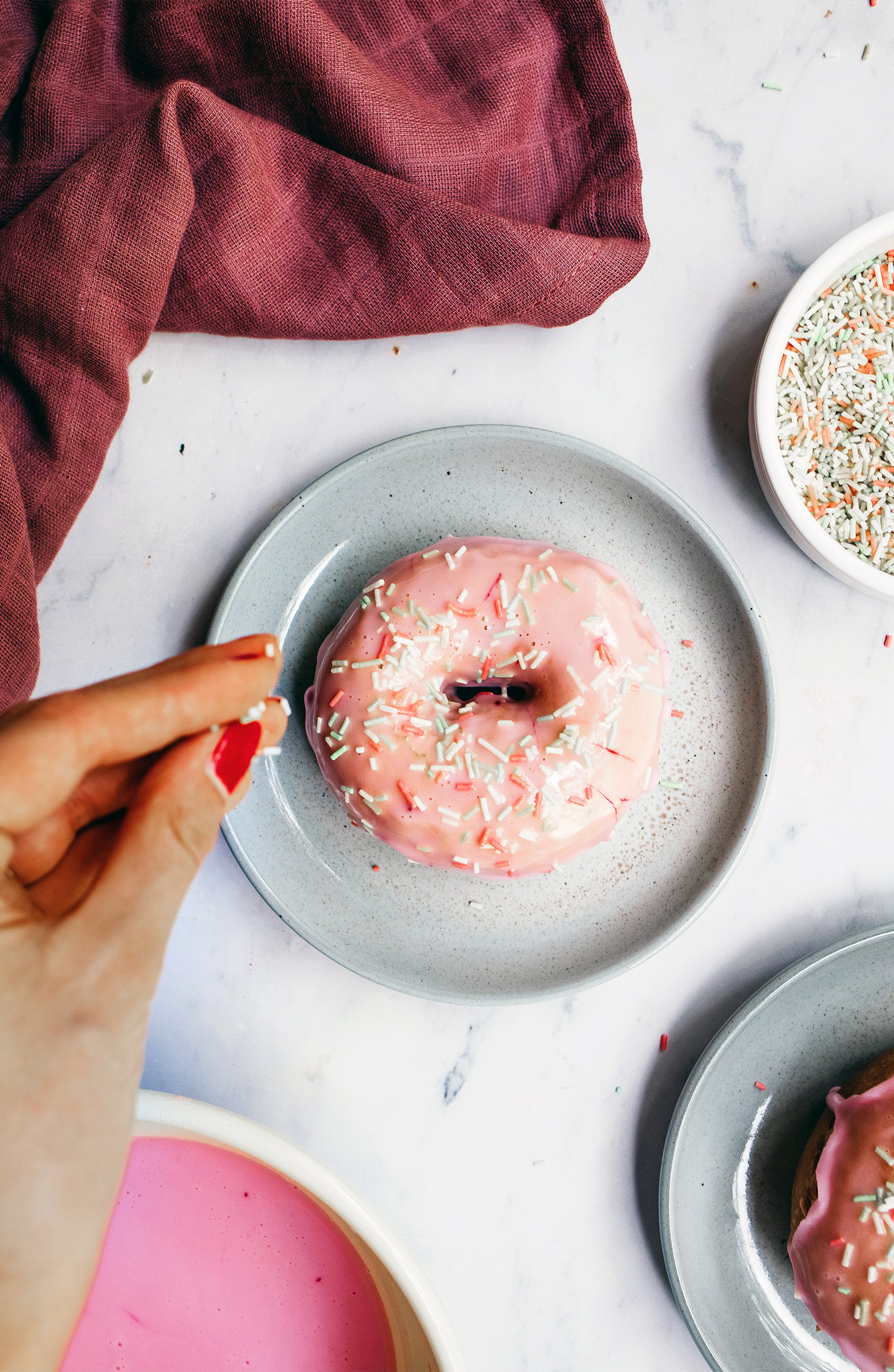 decorating vegan donuts with sprinkles