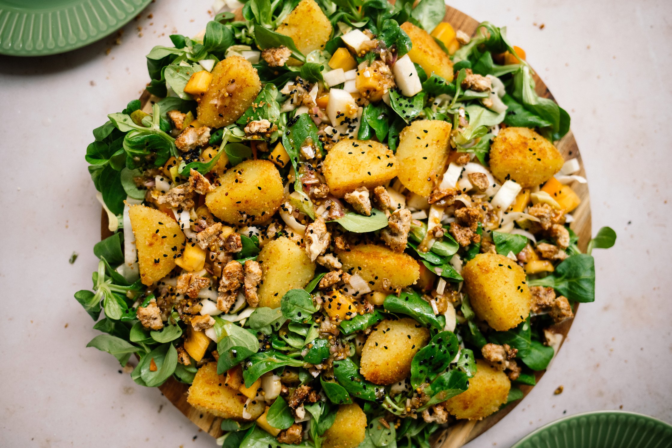 Chicorée-Feldsalat mit Birne, Kaki und Knödel-Croûtons servierfertig