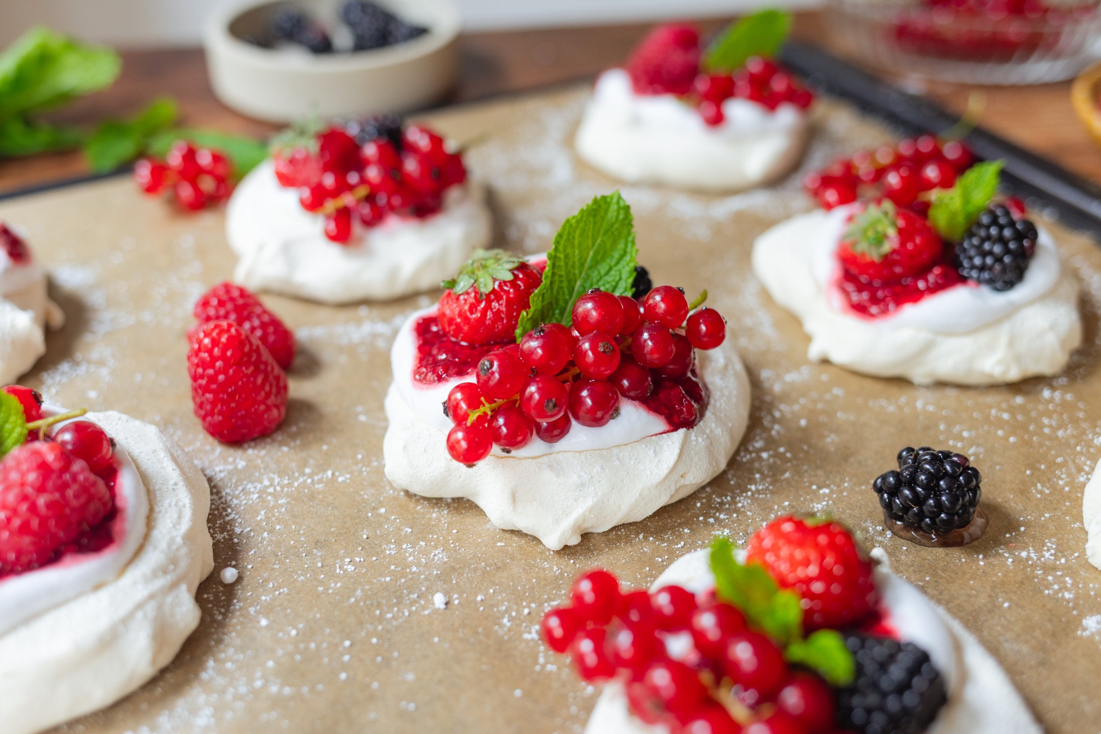 veganes Pavlova mit Sahne und roten Beeren auf einem Backblech