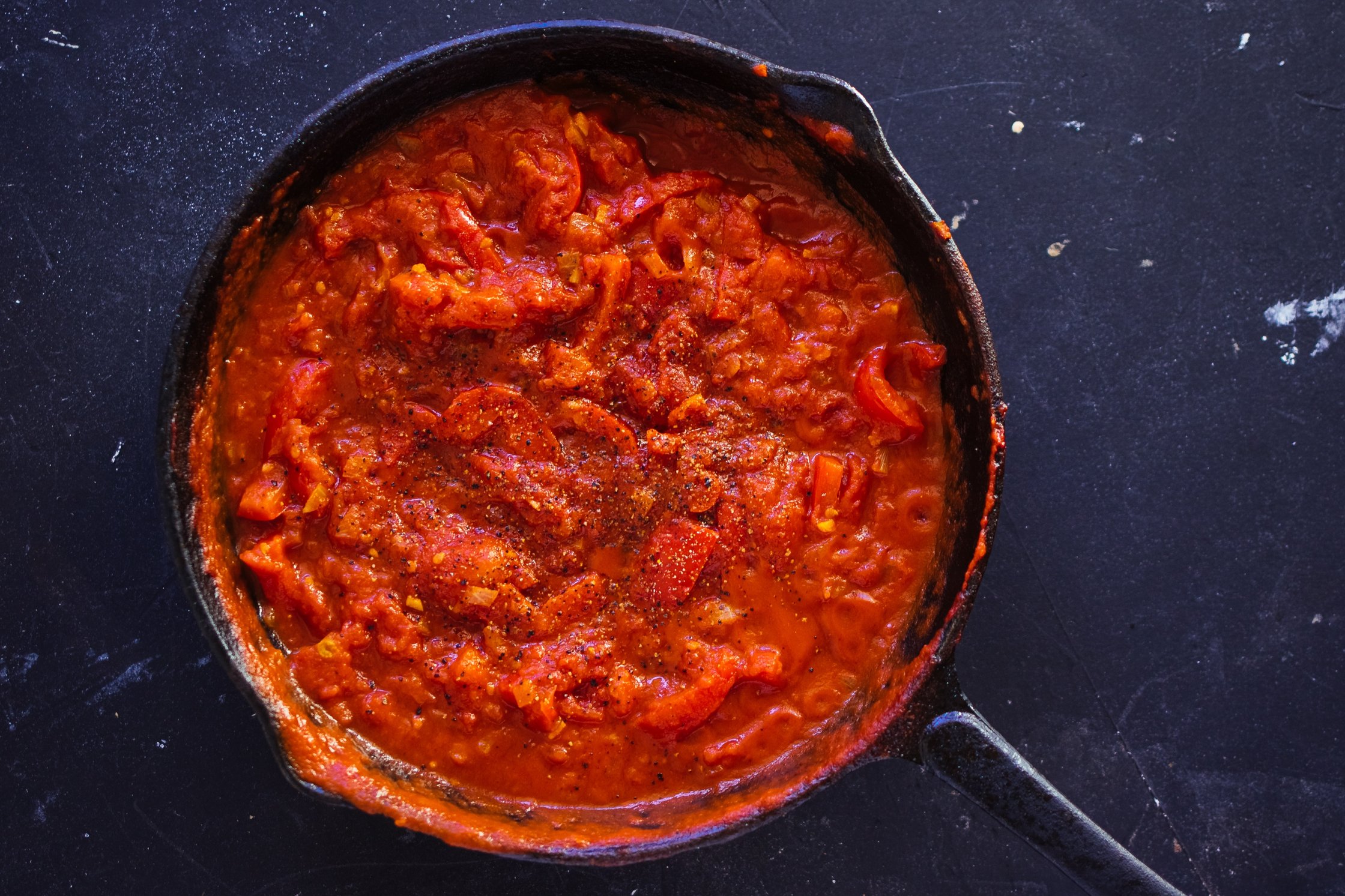 Tomaten und Paprika werden in einer Pfanne eingekocht