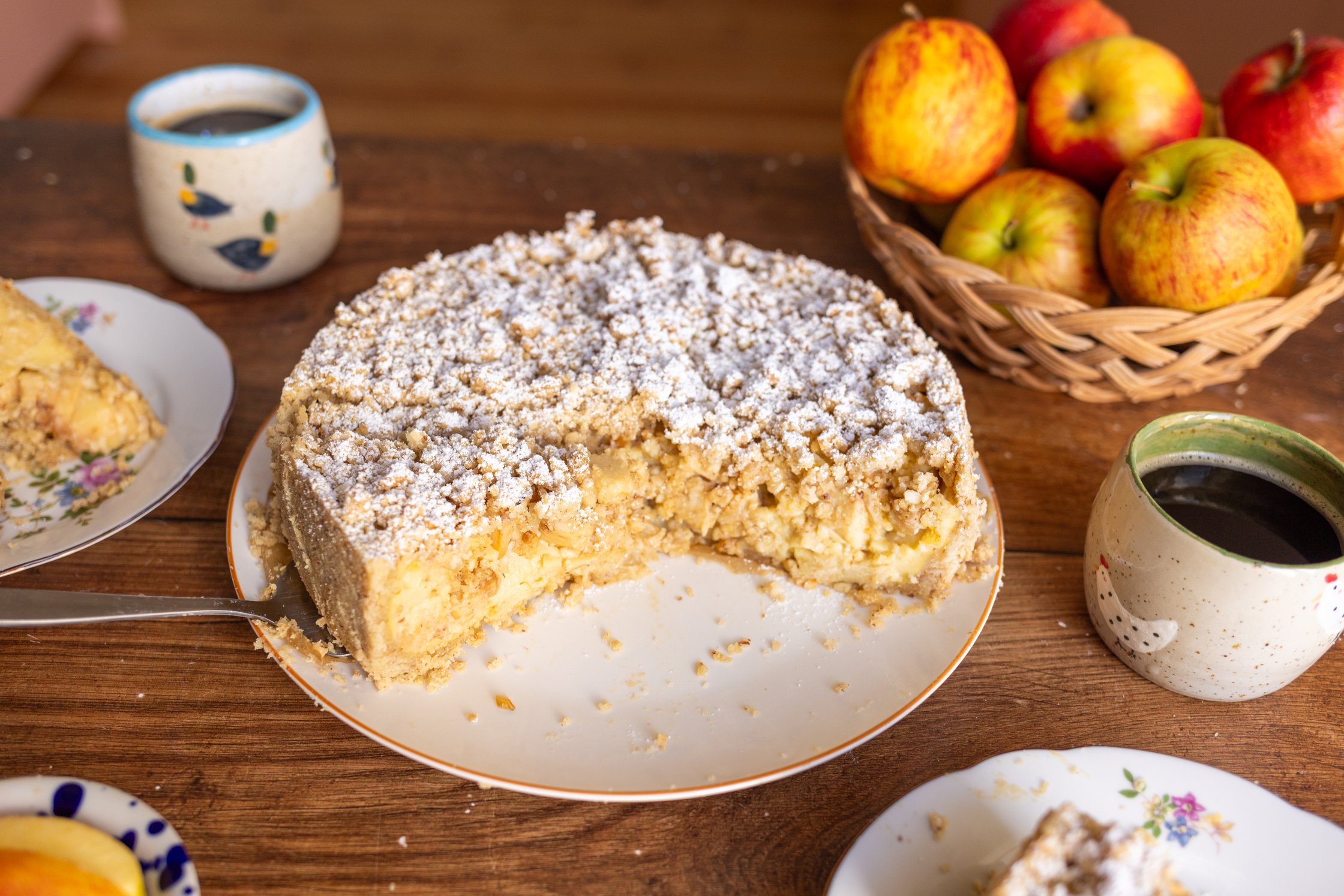 A landscape-format photo. It shows the cut side of the cake, as well as a beautifully set table in the background.