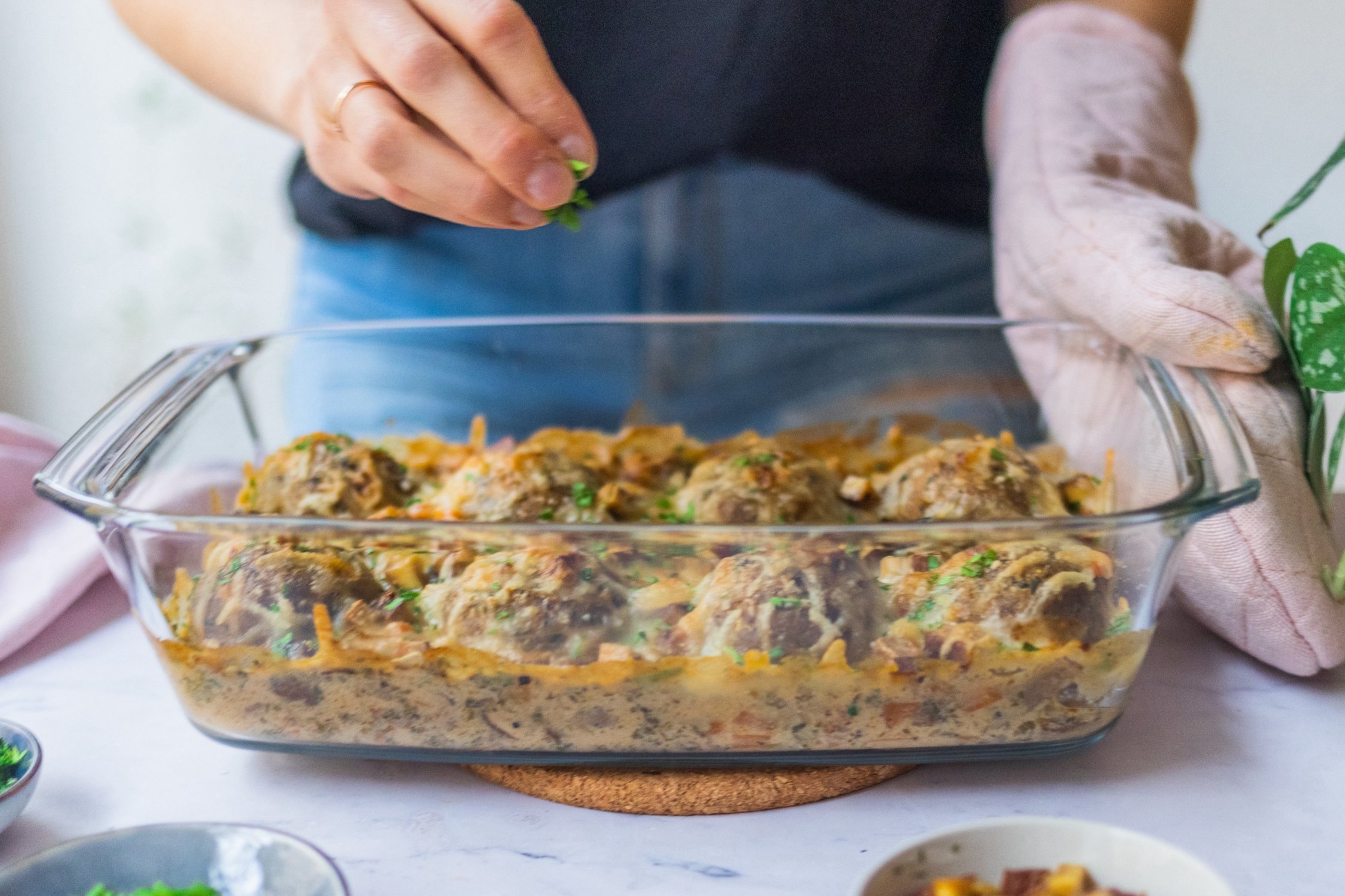 Veganer Semmelknödel-Auflauf mit Champignon-Rahm-Soße vor einem hellen Hintergrund