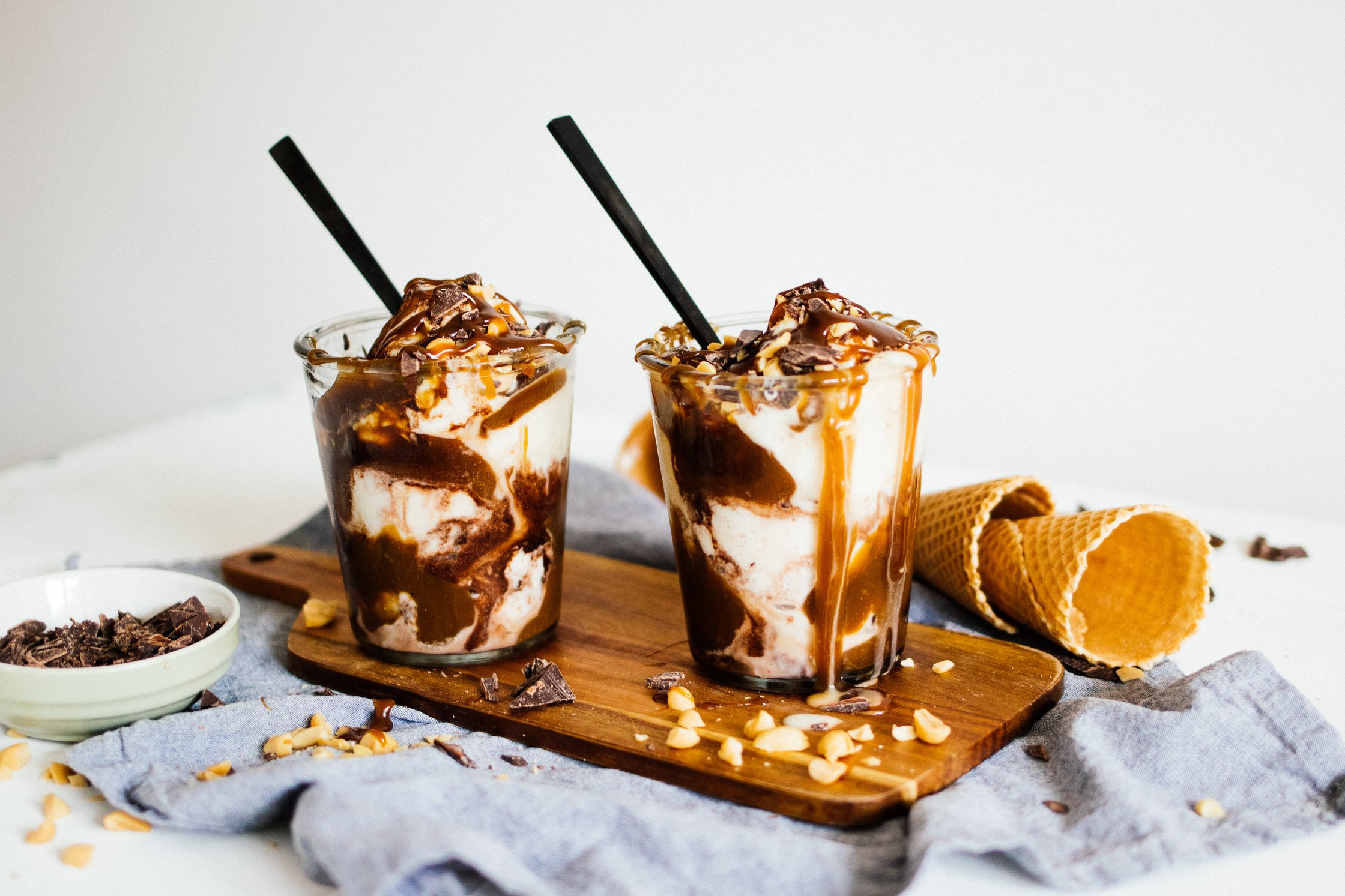 zwei vegane Caramel Eisbecher mit Schokolade und Erdnüssen