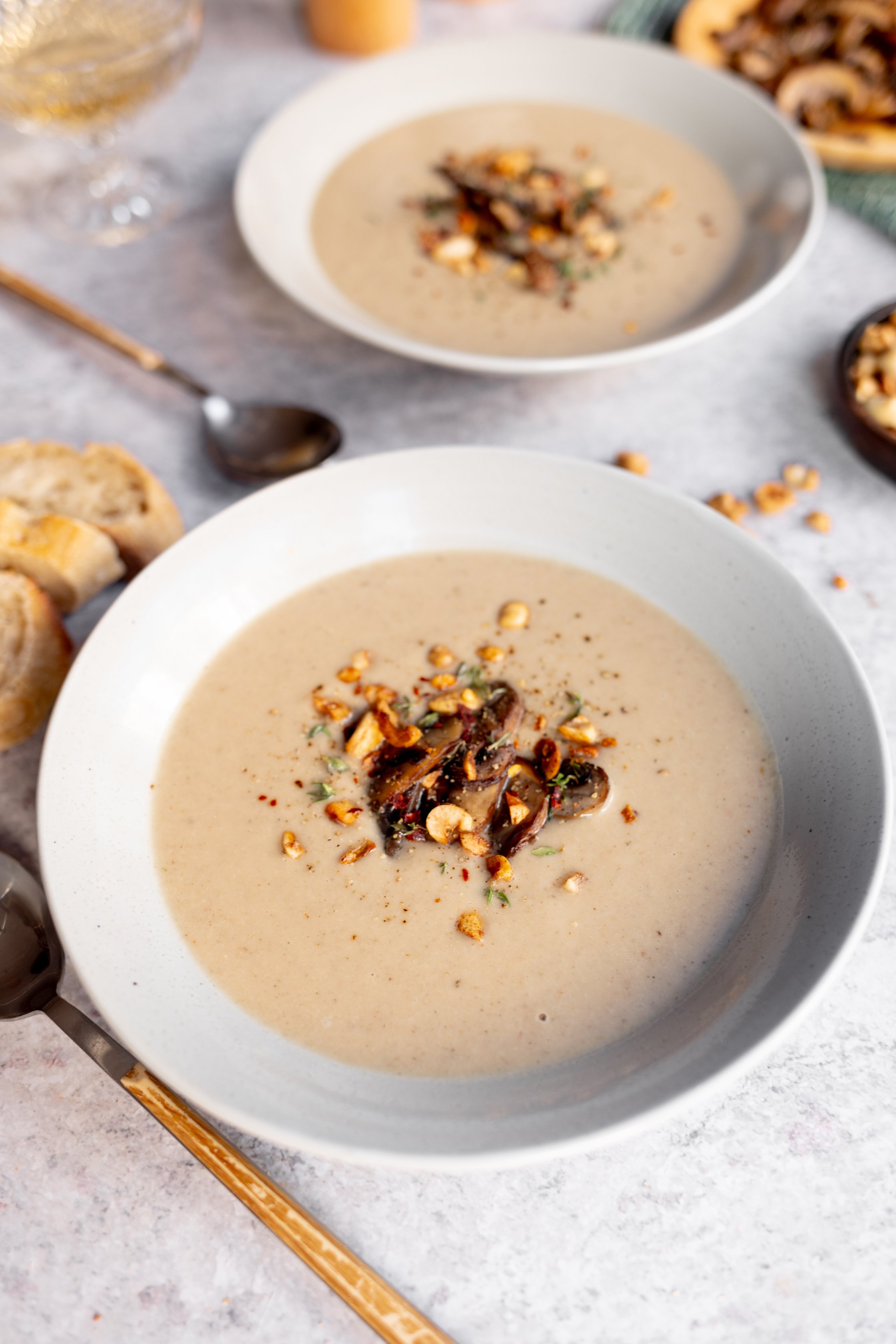 vegane maronensuppe mit Pilz topping und Nüssen, Brot liegt daneben
