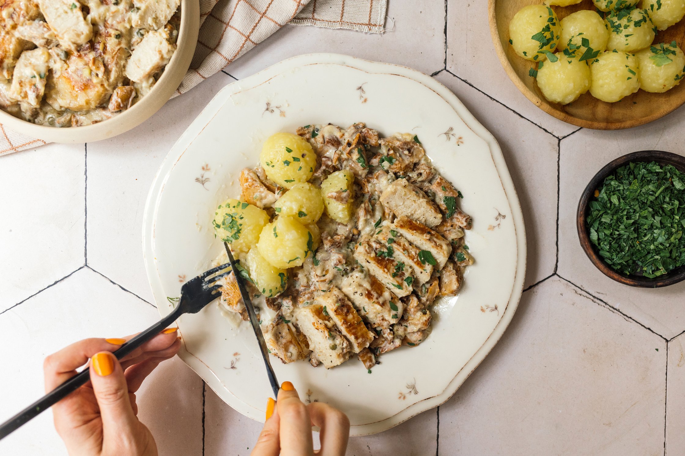 Person isst vegane Filets in Pfifferling-Rahm-Pfeffer-Soße mit Miniknödeln