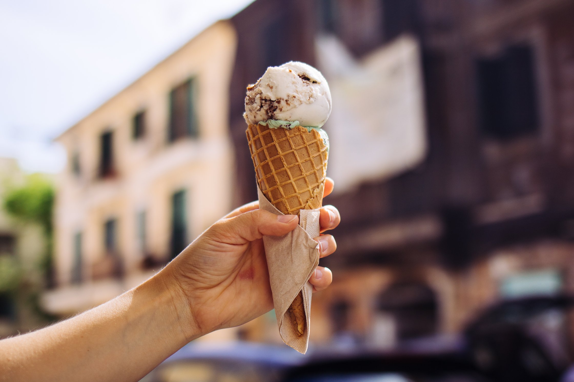a hand is holding an ice cream cone