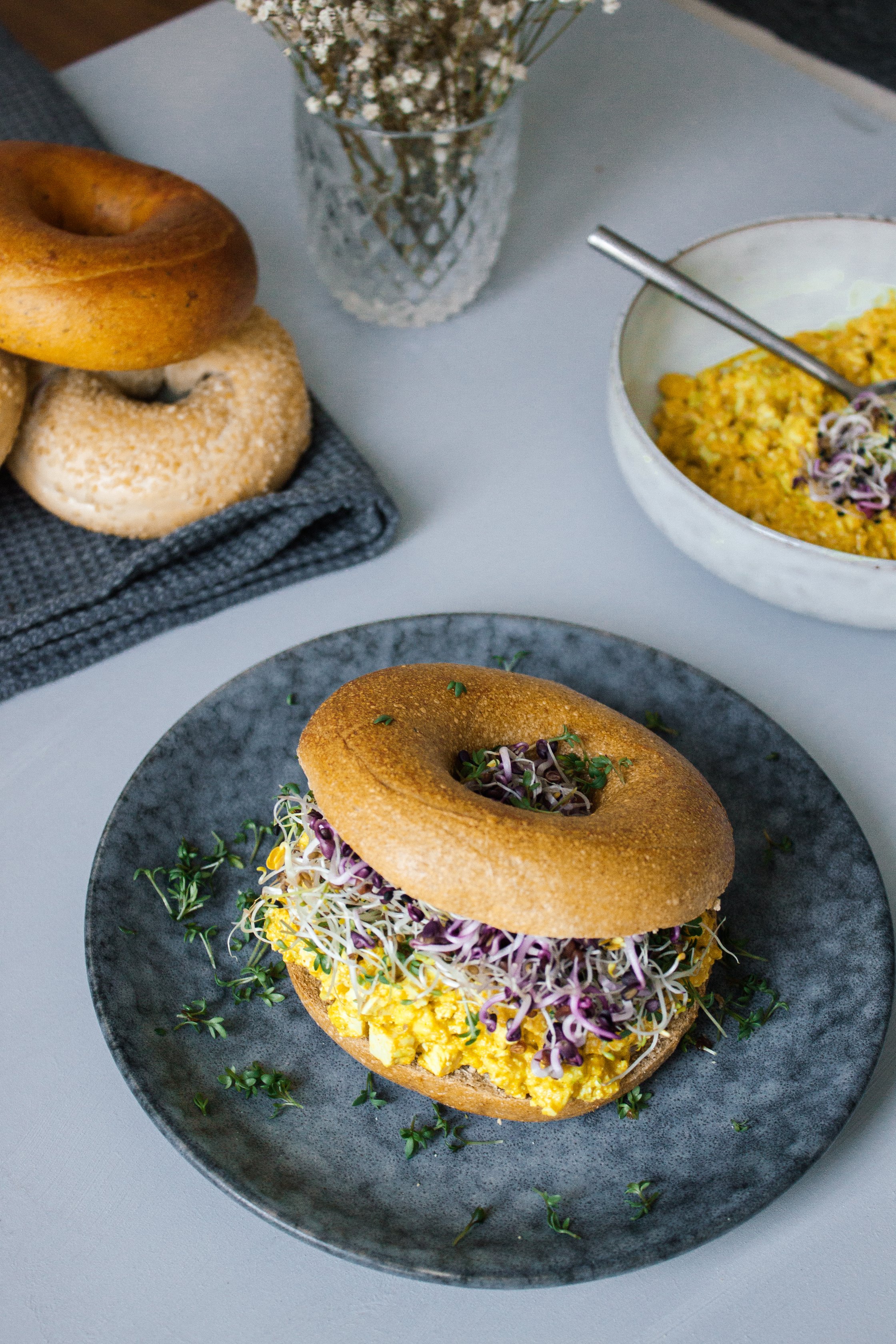 vegan breakfast bagel with ingredients on the table