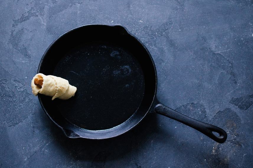 arranging pigs in a blanket in a pan