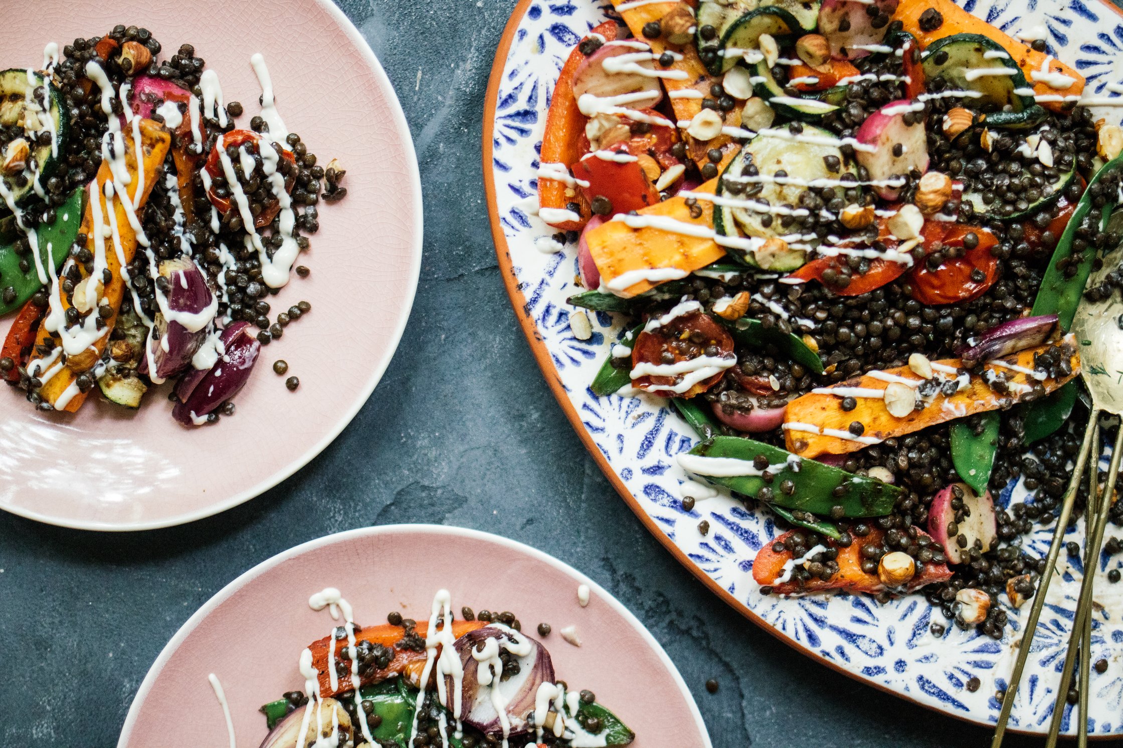 Grillgemüsesalat mit Belugalinsen und Sesamdressing auf tellern