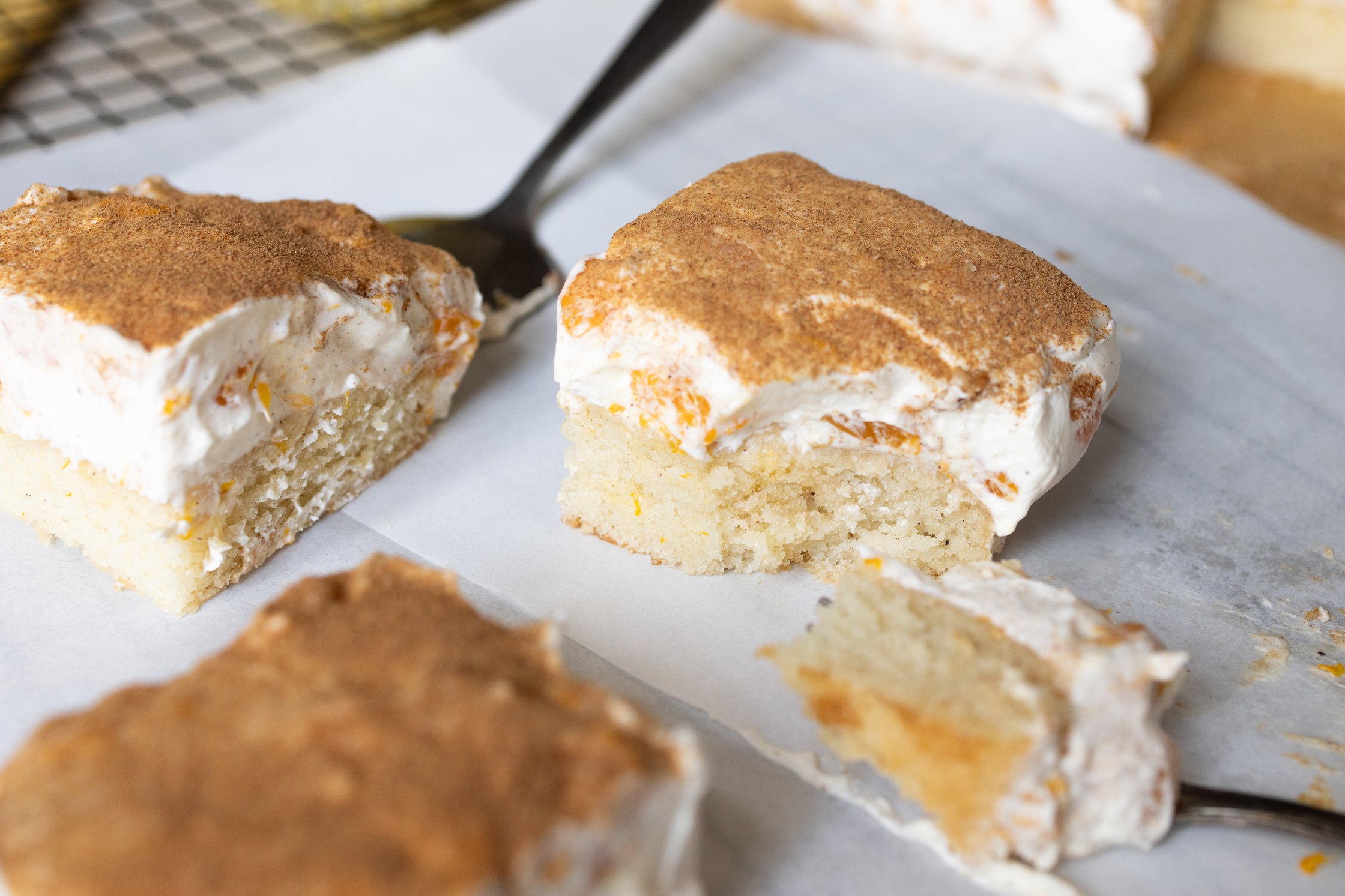 Drei Stücke Fantakuchen auf eine, hellen Untergrund. Ein Stück ist mit der Gabel abgeteilt und liegt daneben.