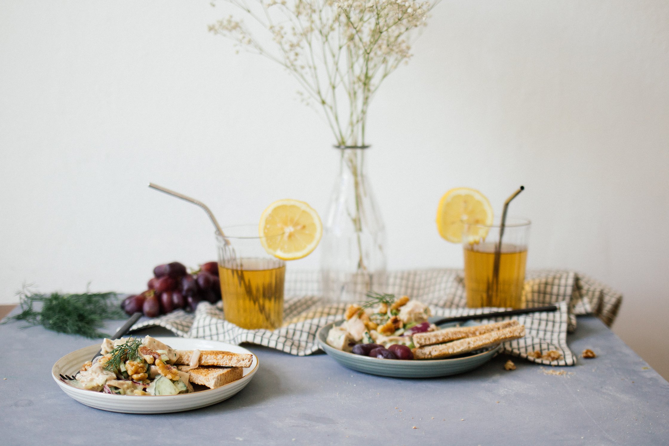 chicken salad is served with drinks and flowers