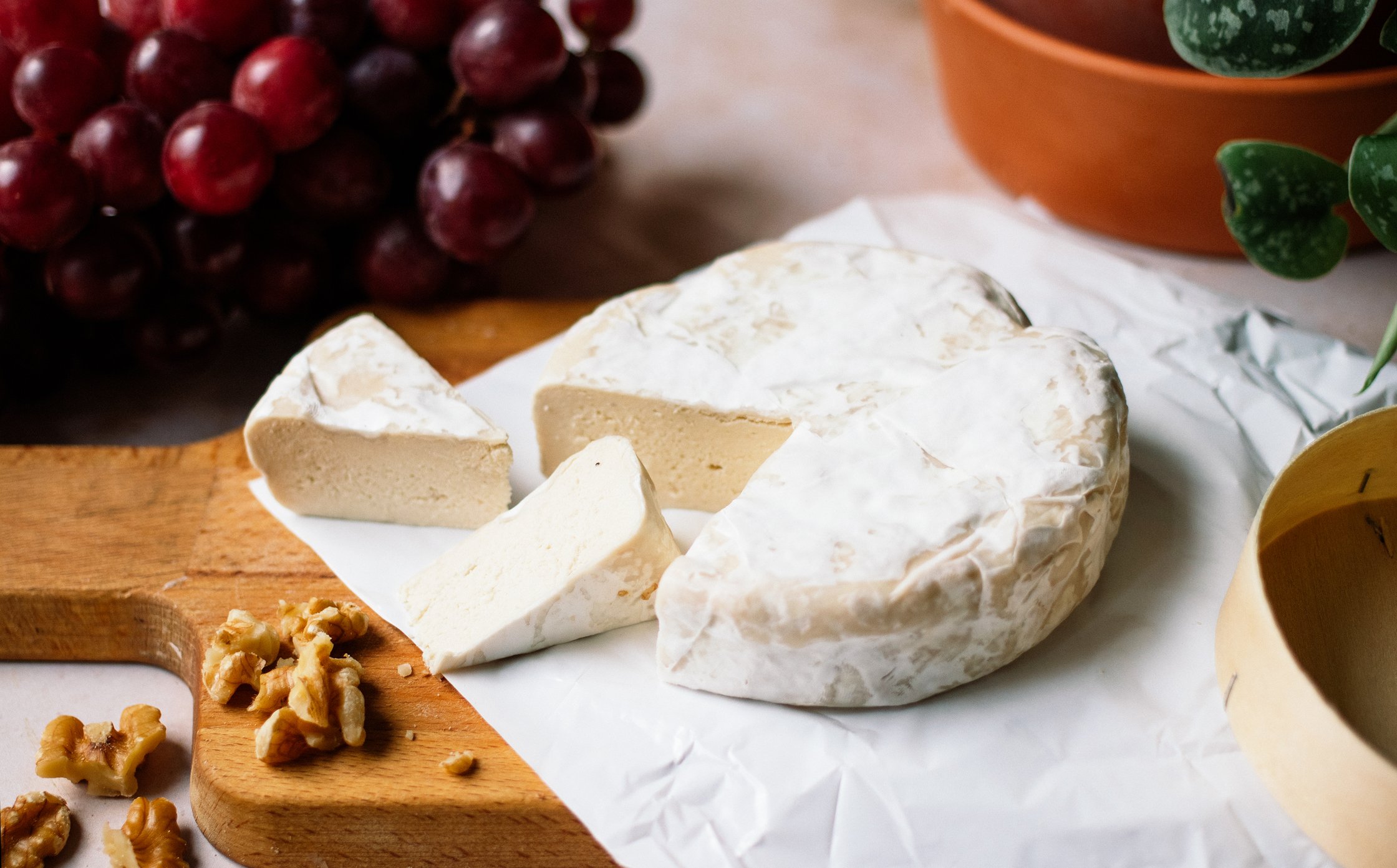 angeschnittener veganer camembert auf einem schneidebrett