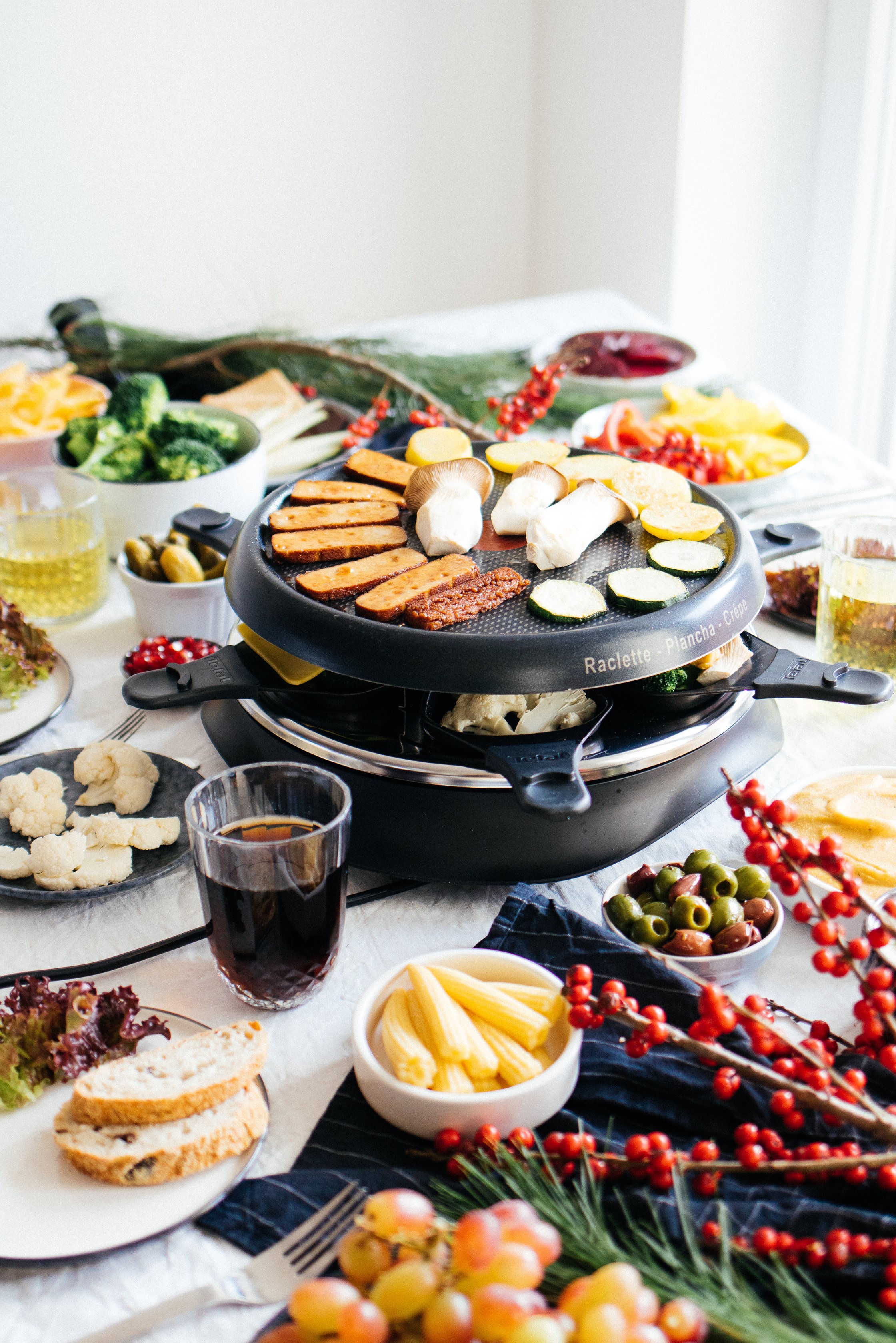 raclette on a table, lots of filled bowls around
