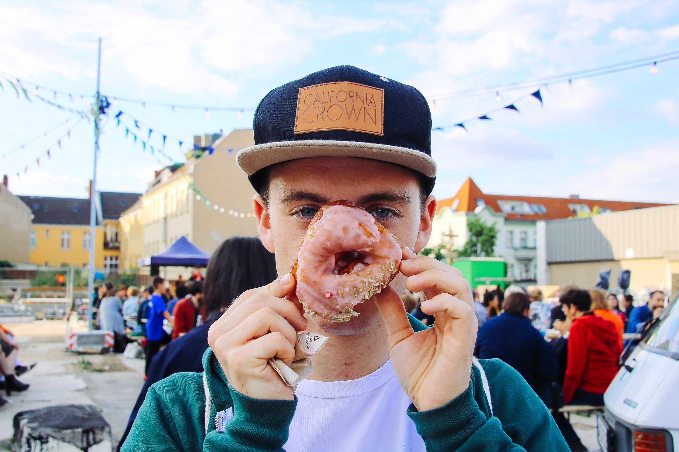 ein Junge hält sich einen Donut vors Gesicht