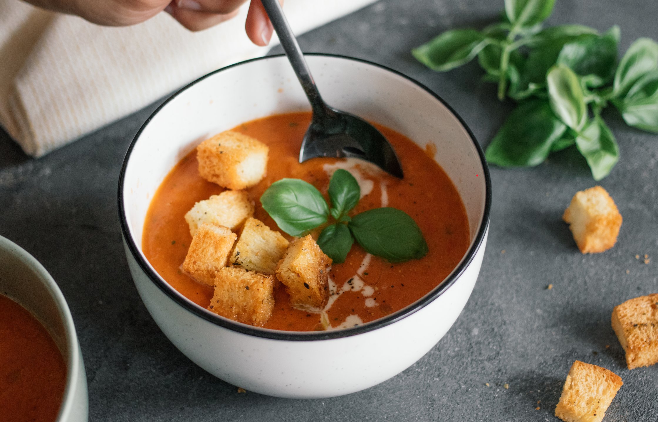 spooning into Vegan Oven Roasted Tomato Soup