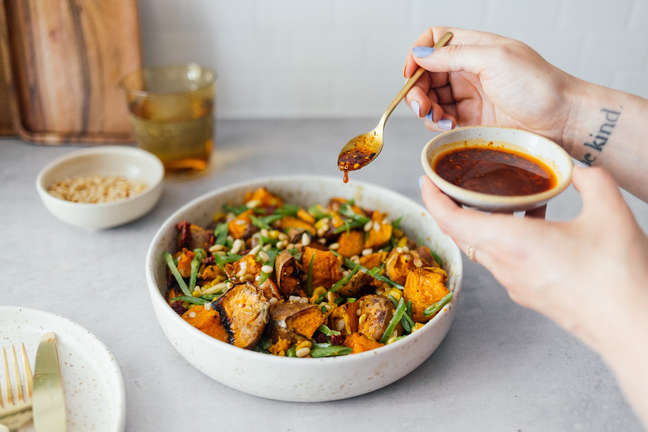 Chili-Crunch über gebackenen Süßkartoffelsalat geben
