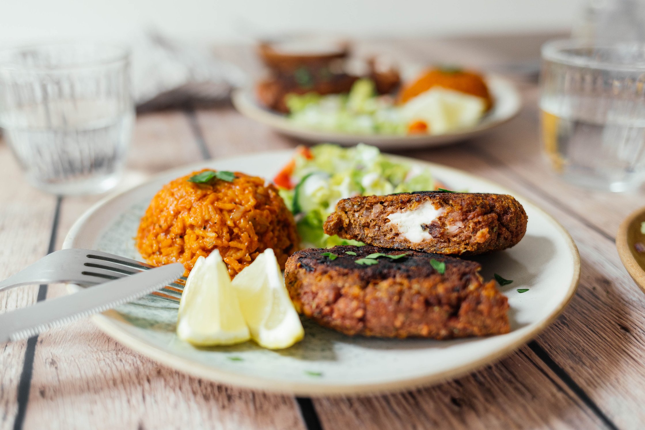 vegan Bifteki-Steak with tomato rice and salad on a plate