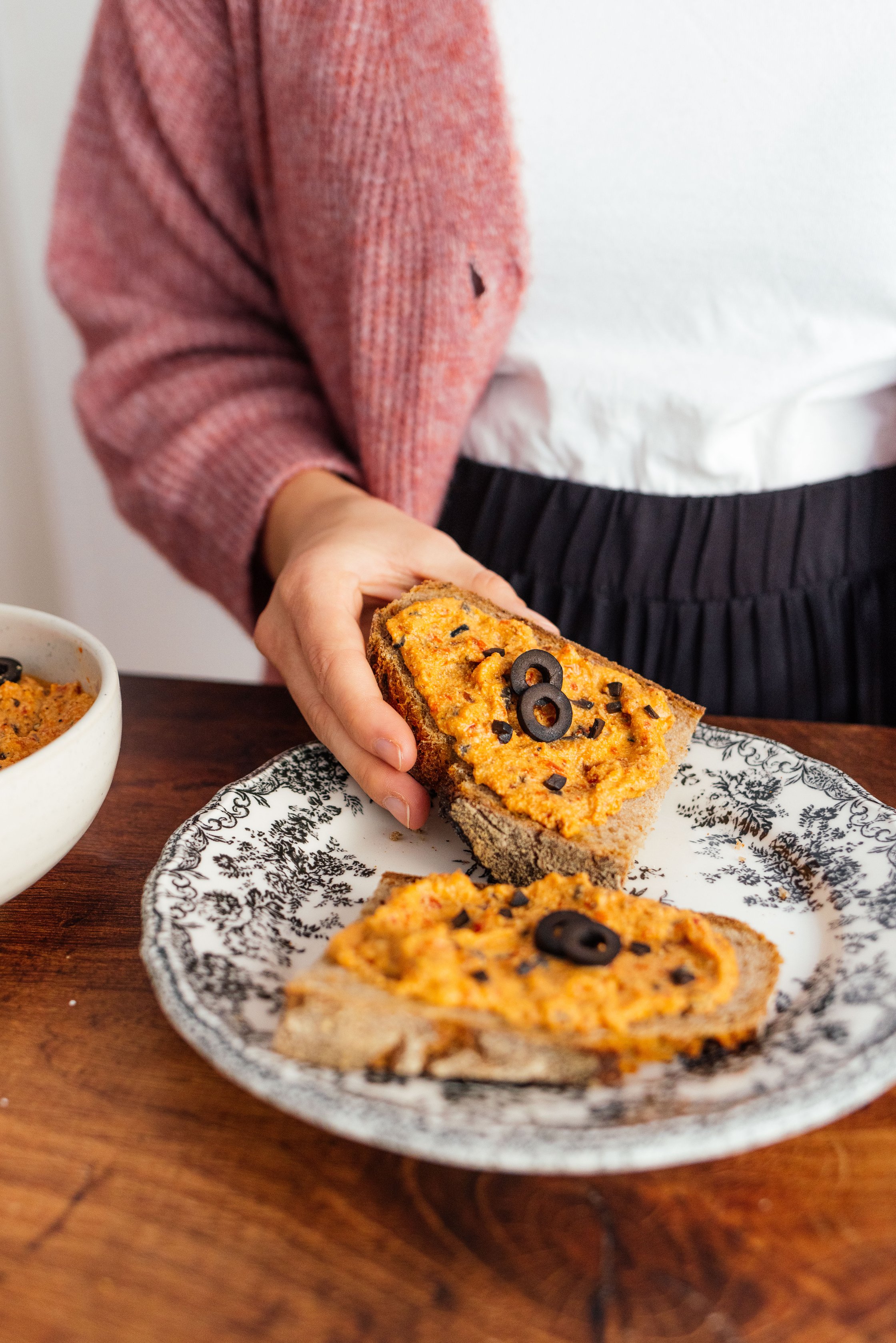 veganer Aufstrich mit gegrillter Paprika, Räuchertofu und Oliven auf einer Scheibe Brot