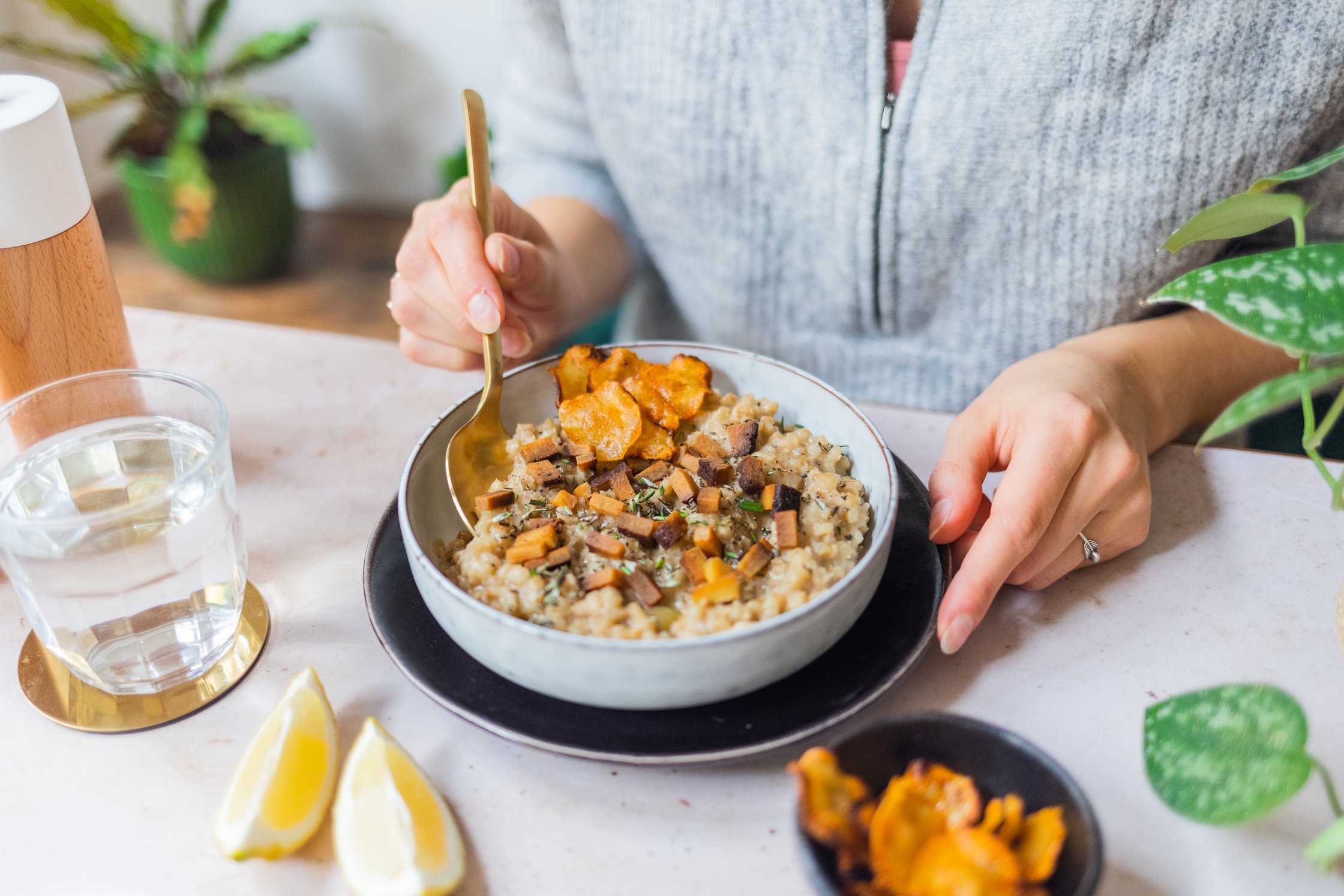 Veganes Gerstenrisotto mit Topinamburchips wird gegessen