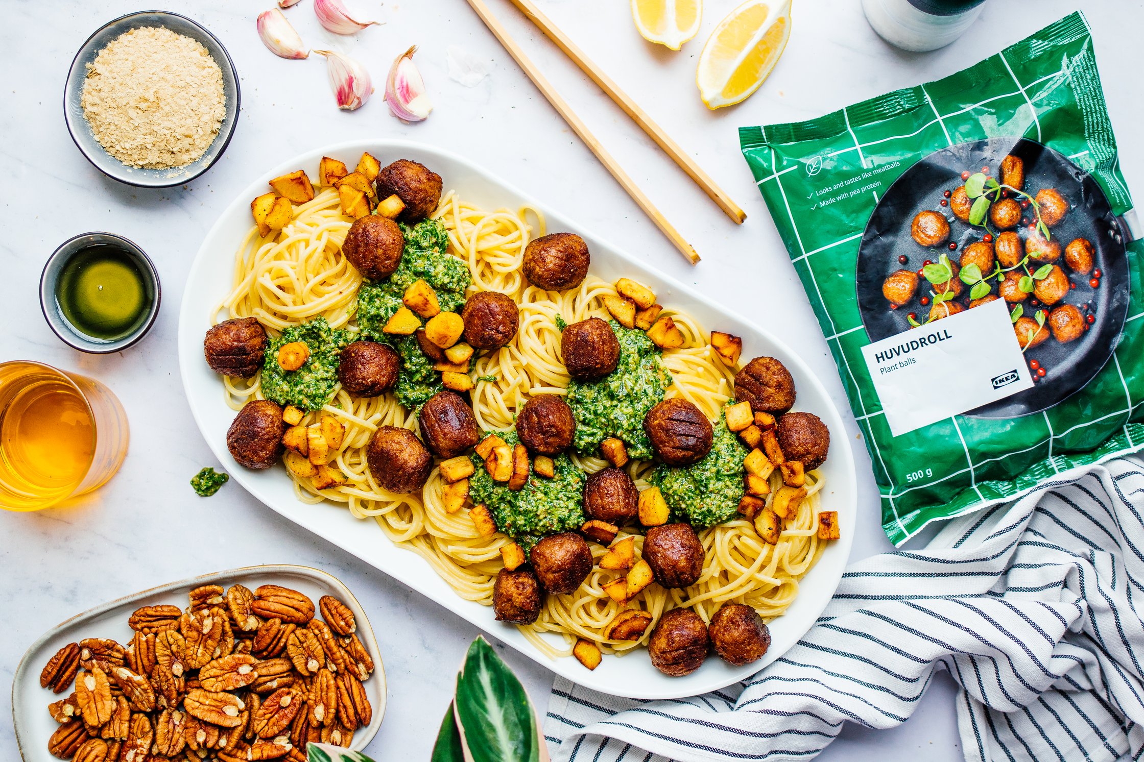 spaghetti with pesto and meatballs on a big platter