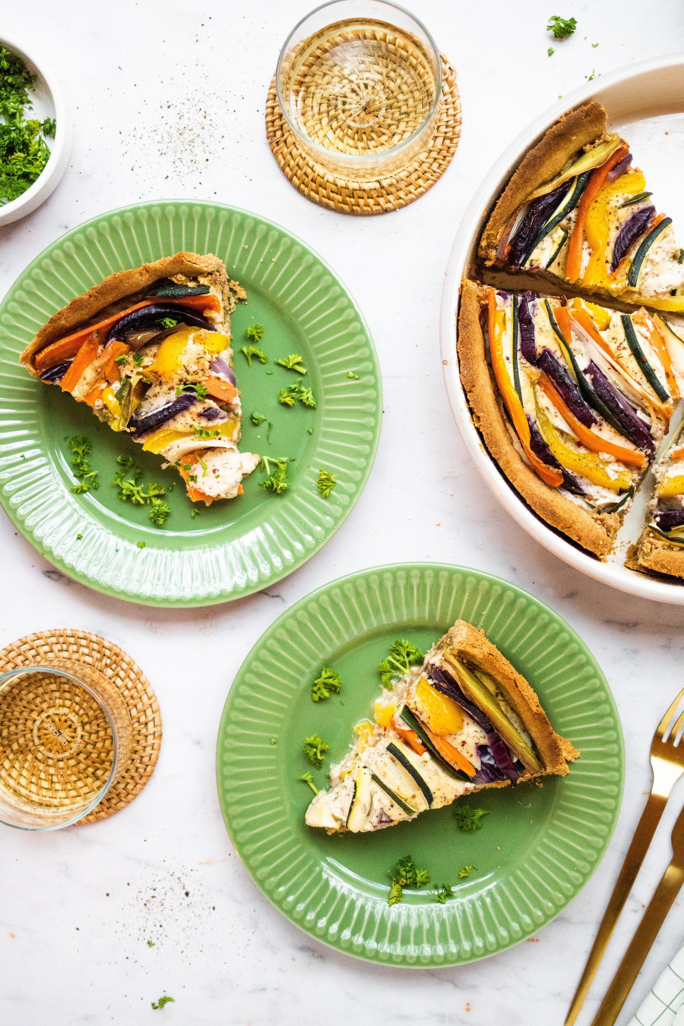 Vegan Vegetable Quiche on plates, with glasses