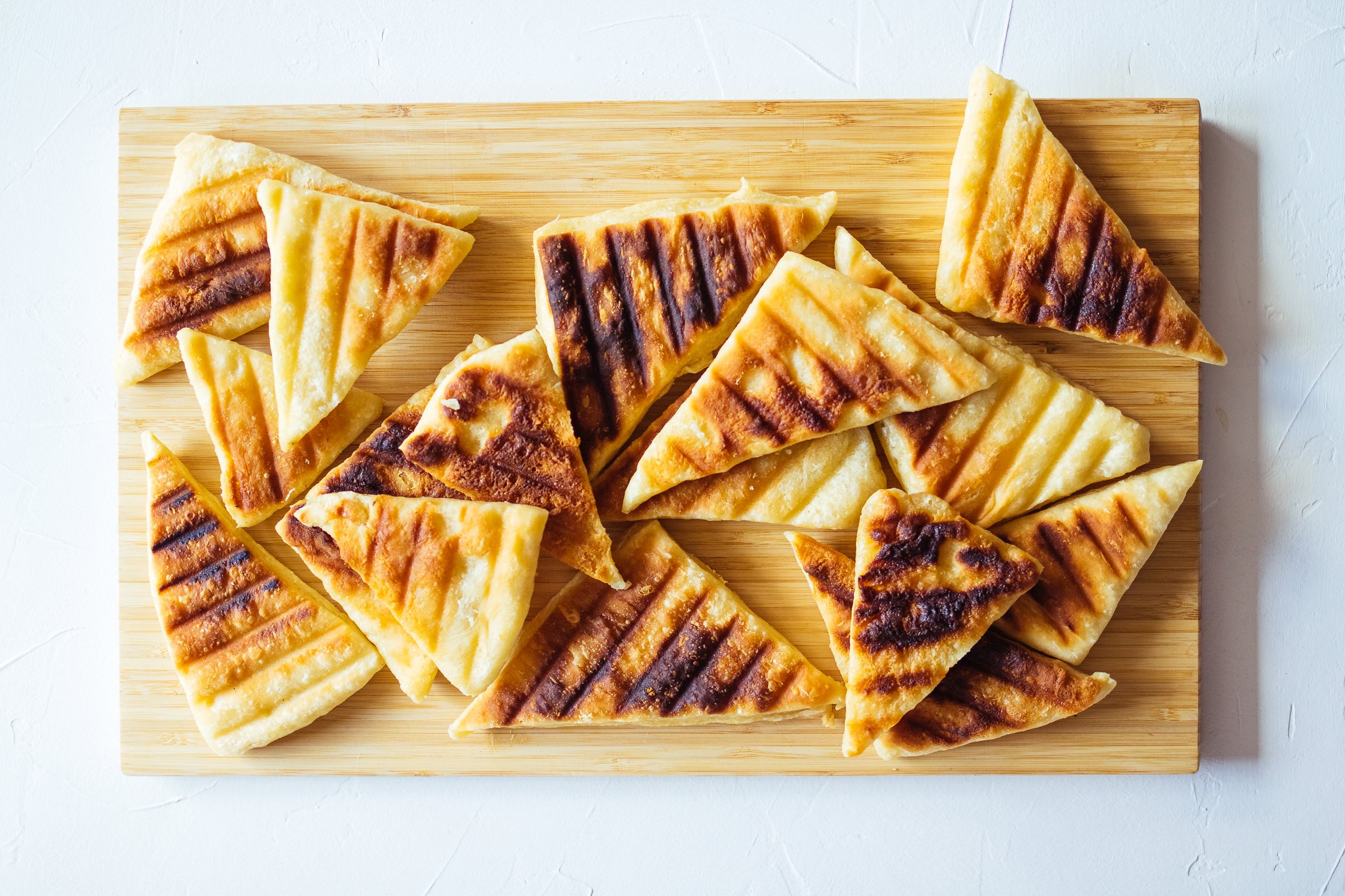 Gegrillte Brotecken auf einem Holzbrett