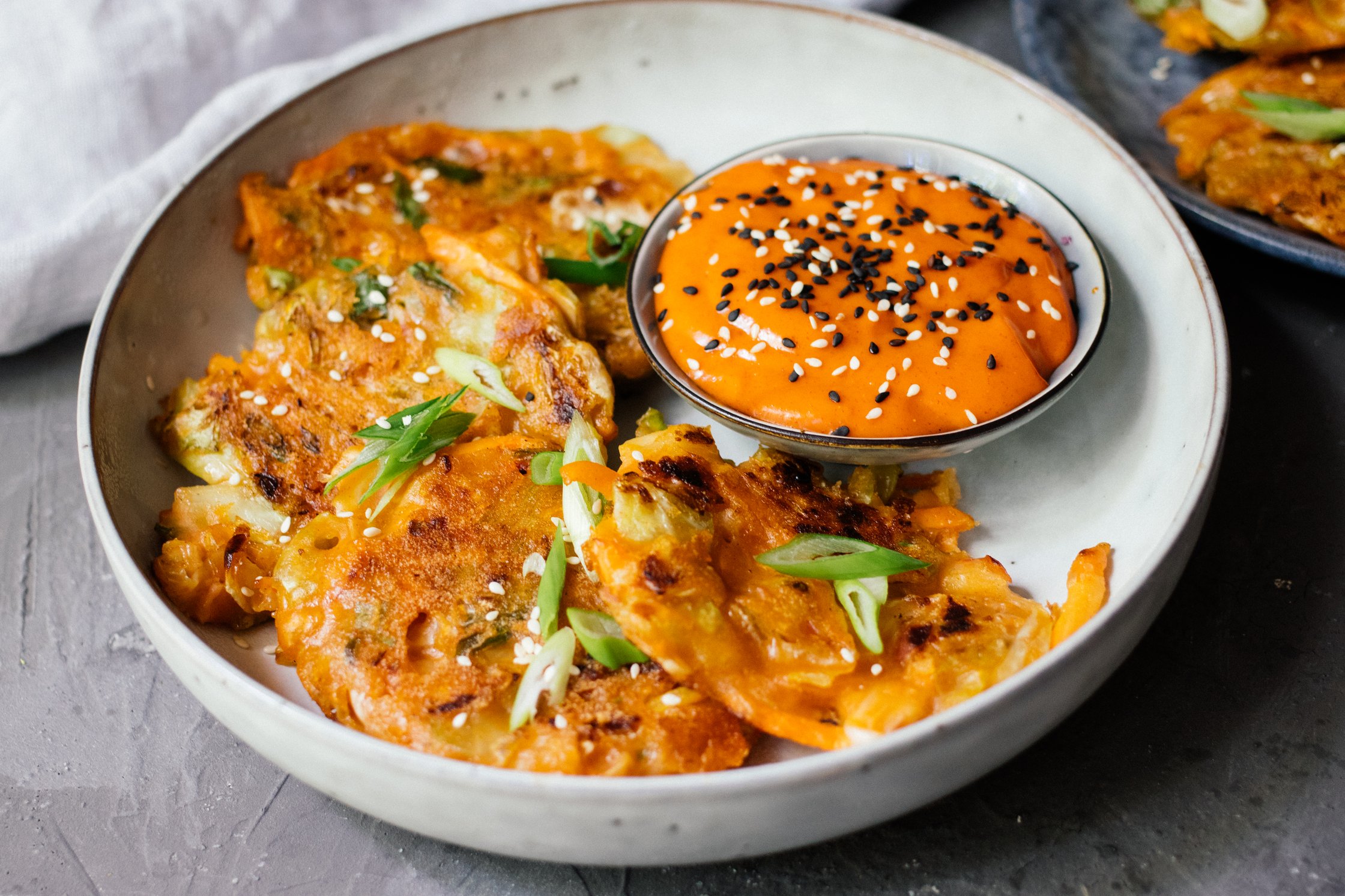 vegan kimchi pancakes in a bowl with dip