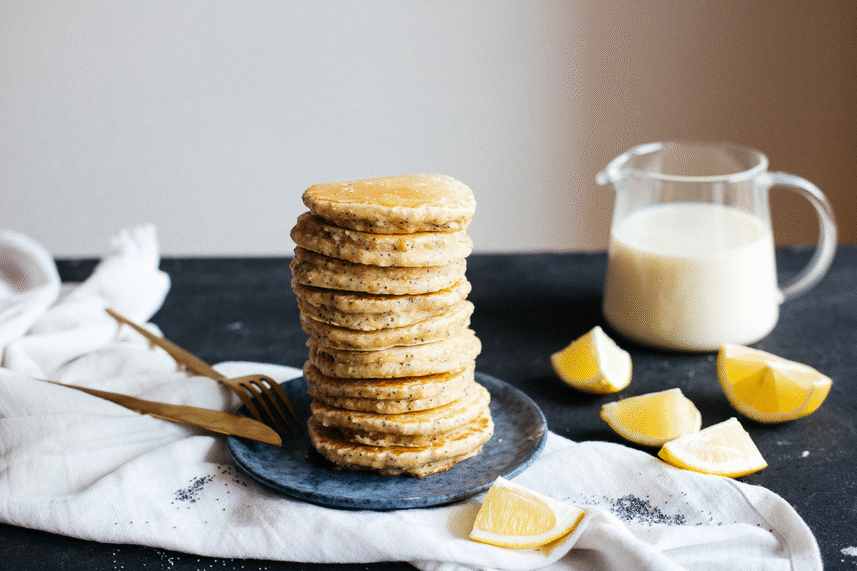 pouring maple syrup on pancakes