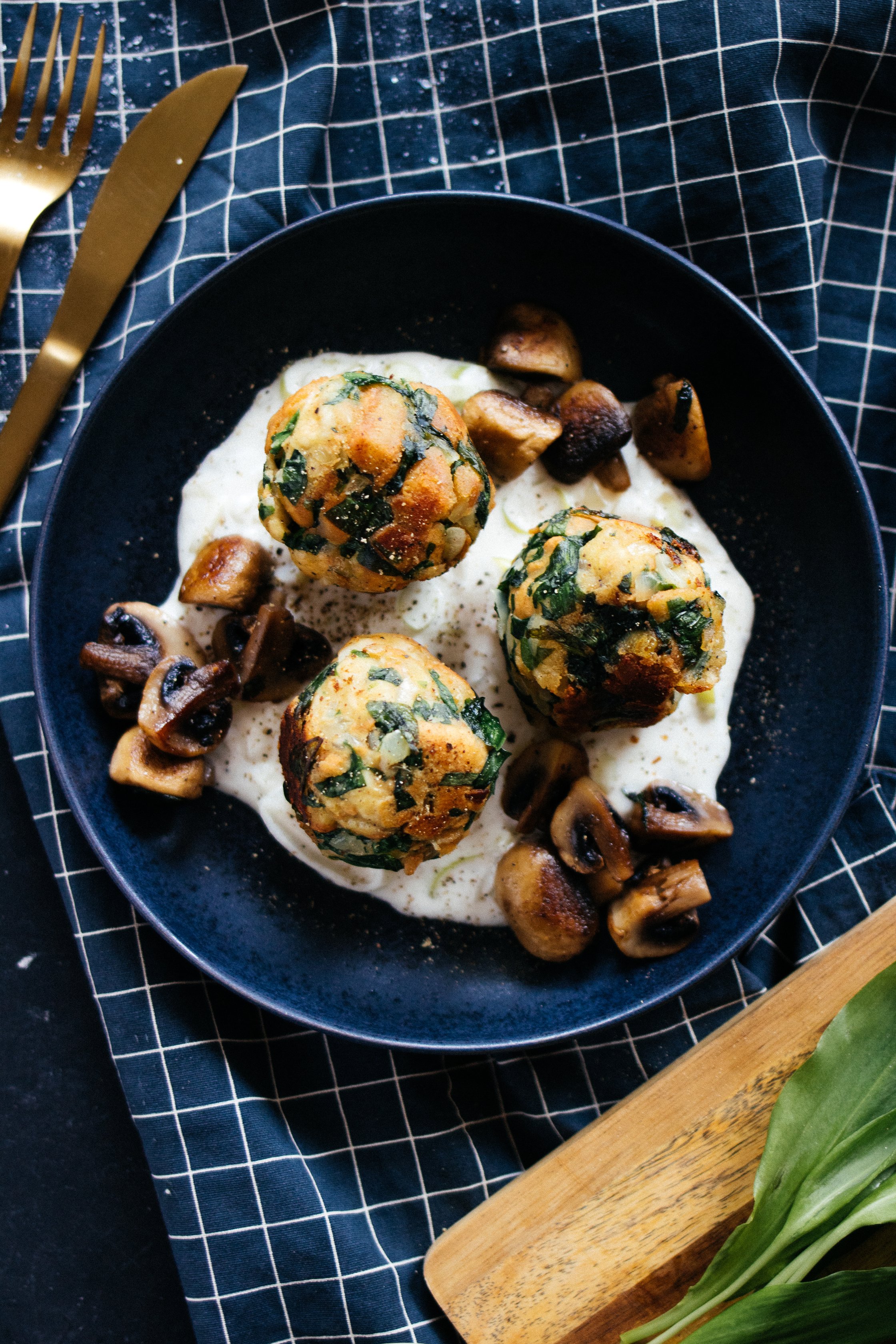 3 vegan dumplings with wild garlic on a black plate