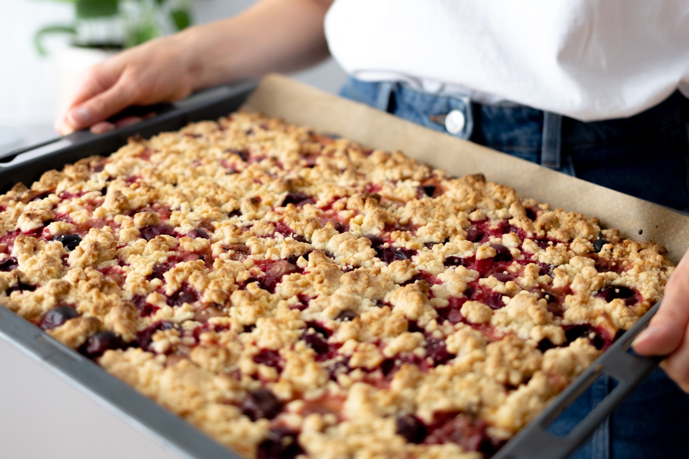mehrere stücke veganer streuselkuchen, der mit Puderzucker bestreut wird