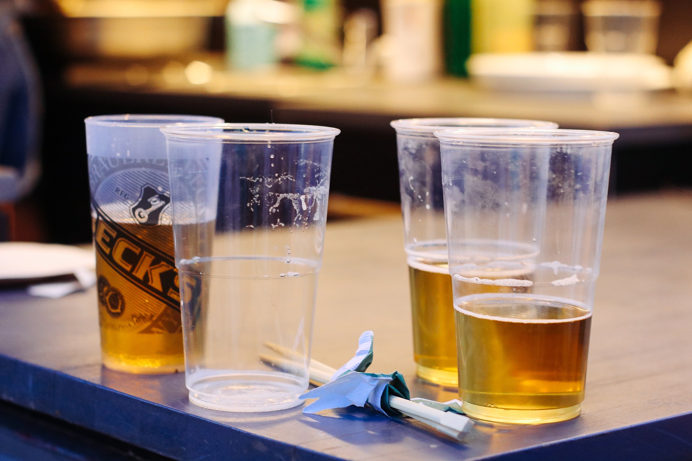 vier Plastikbecher mit Bier gefüllt