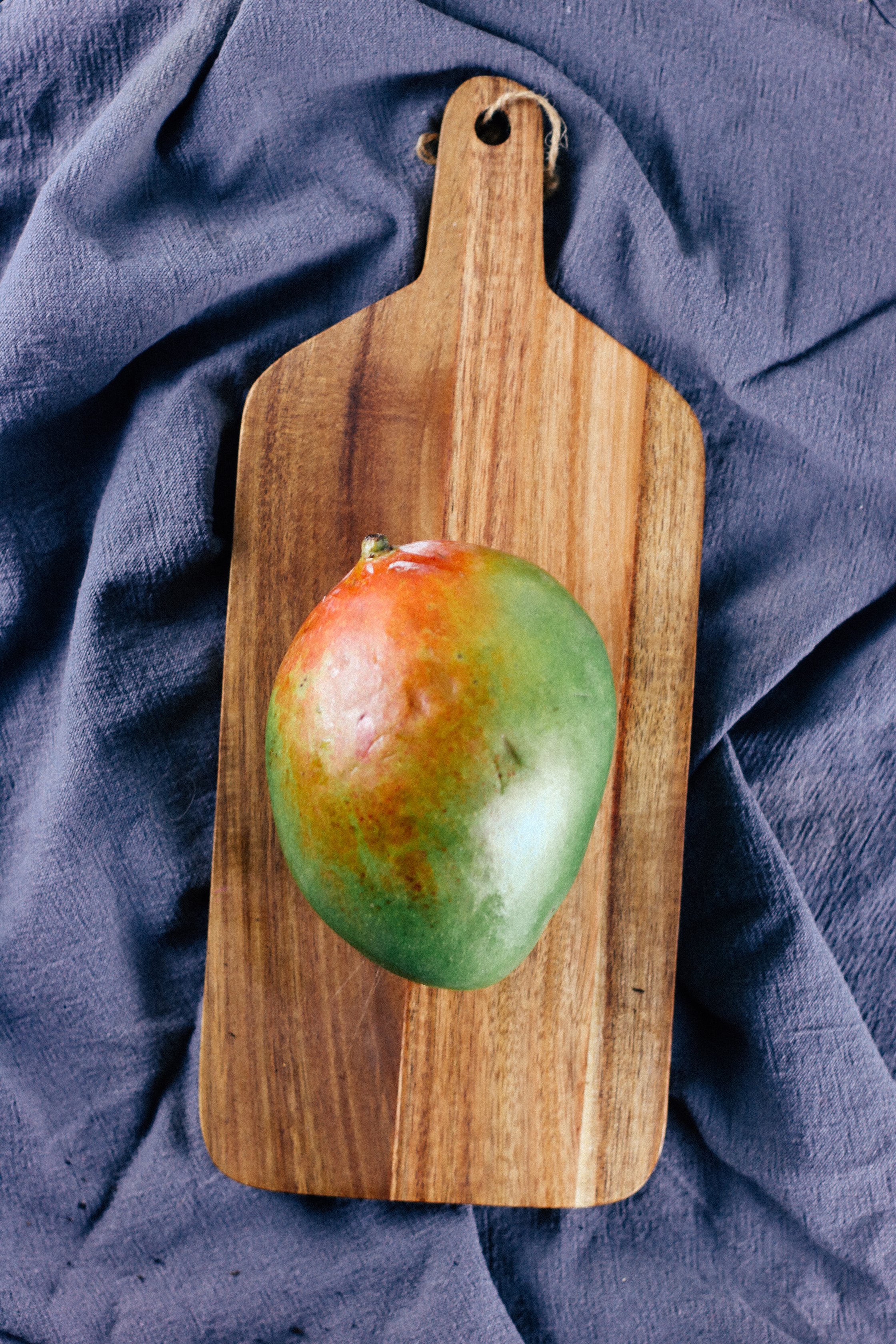 a mango is laying on a cutting board