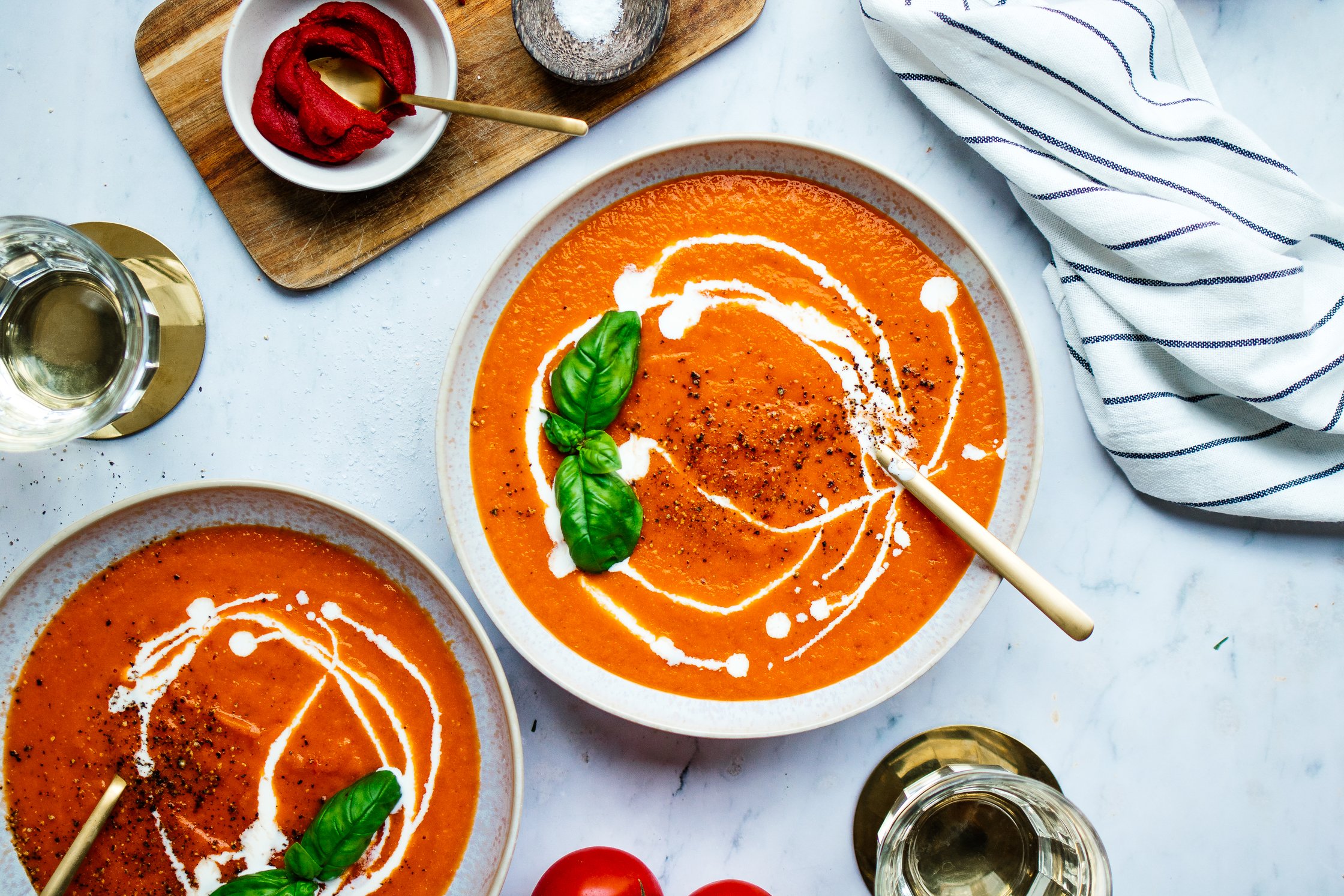 vegan tomato soup in a bowl topped with basil