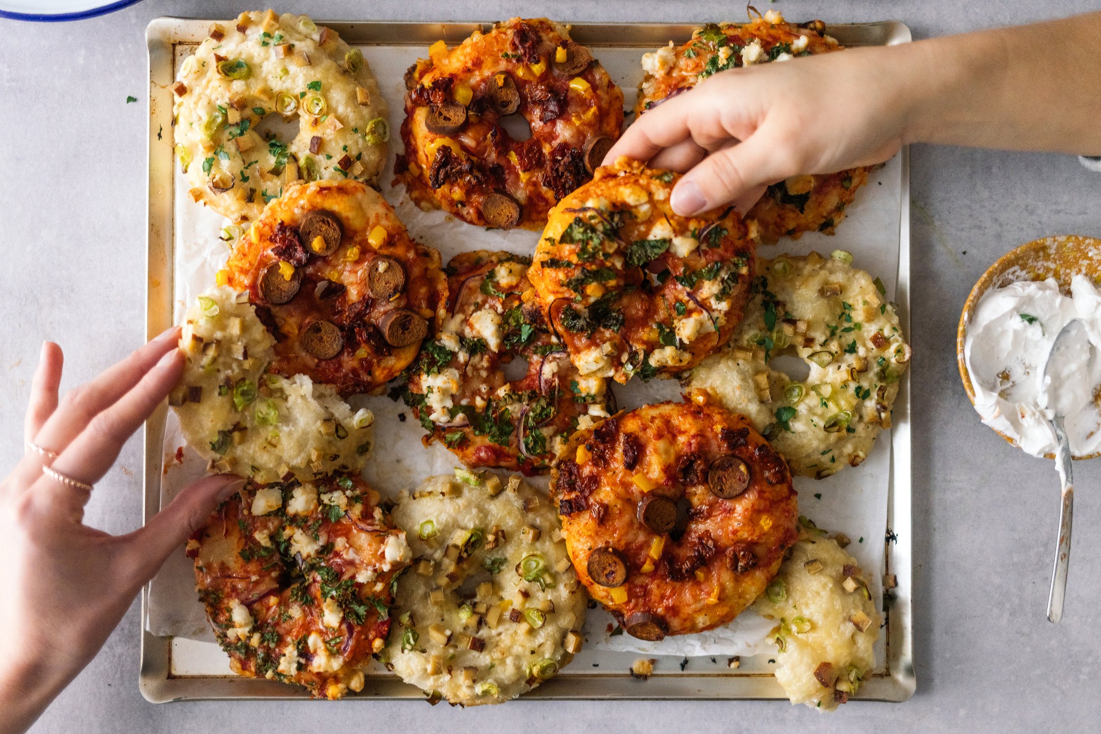 hands grabbing for vegan pizza donuts