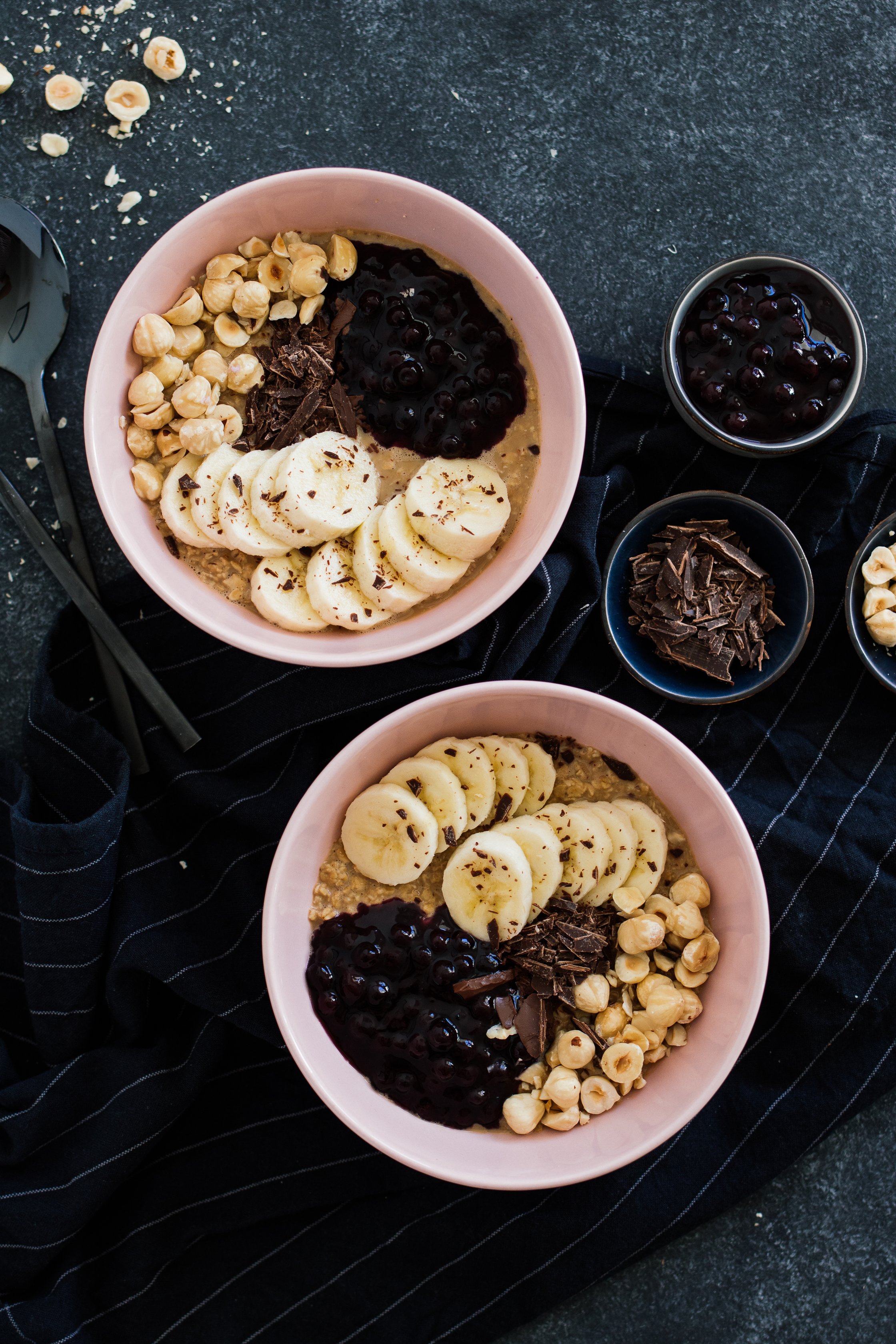veganes Chai-Porridge in rosa Schalen mit Schokolade und Heidelbeeren