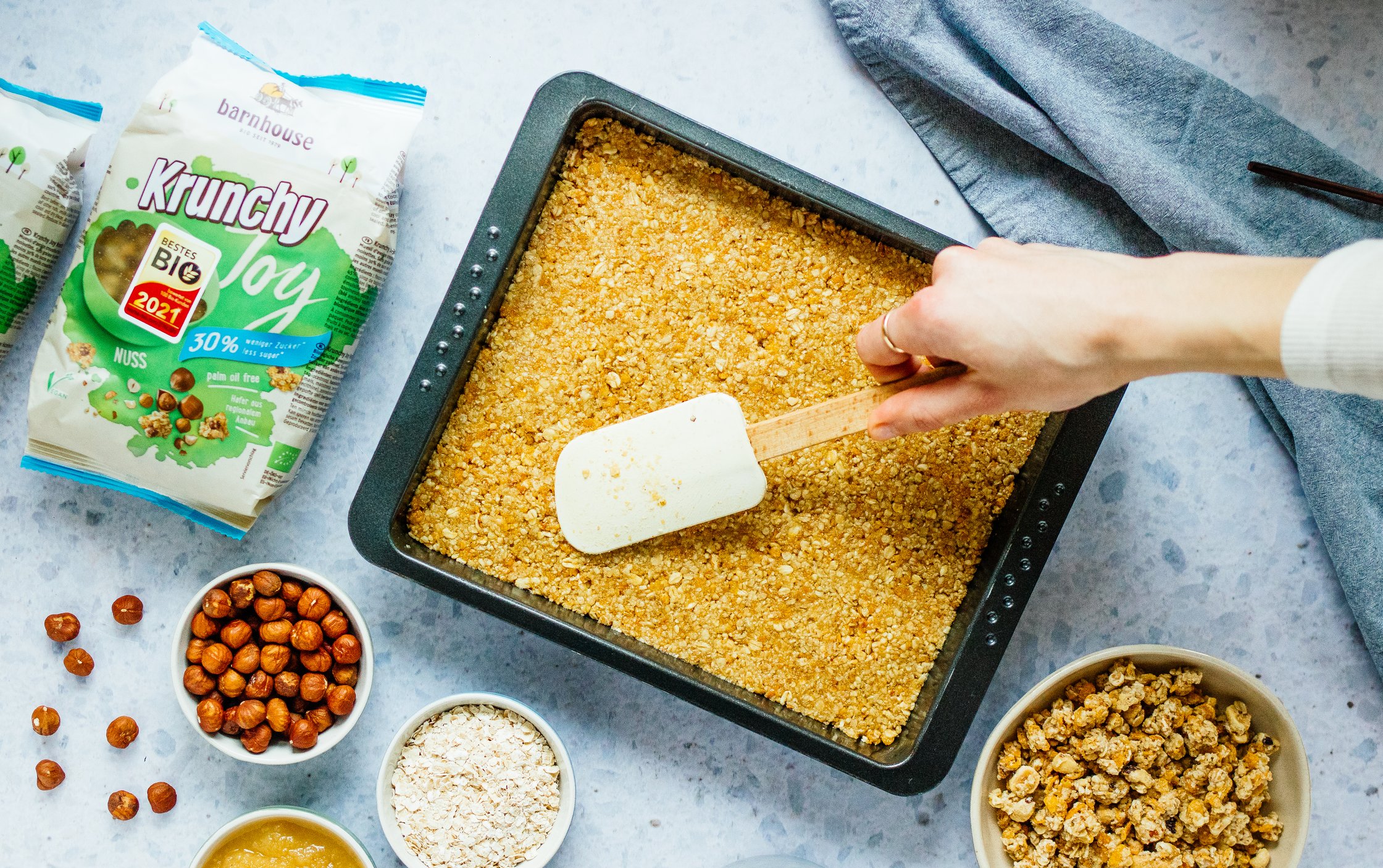 die Haselnuss-Müsli-Schicht wird in eine Form gedrückt